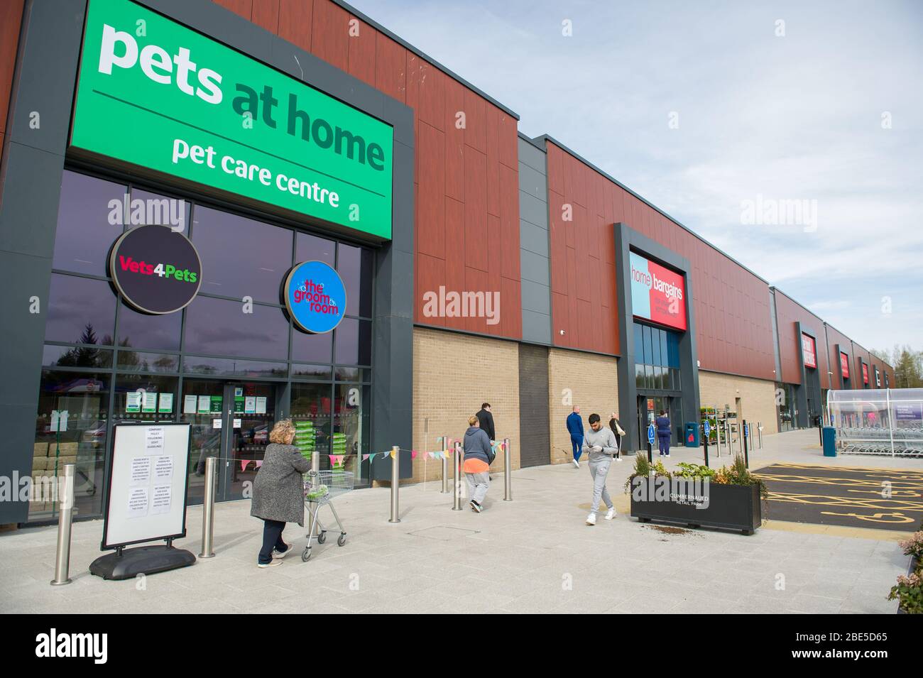 Cumbernauld, Royaume-Uni. 12 avril 2019. Photo : les clients font la queue en dehors d'un magasin de vente à domicile tout en gardant les distances sociales. Scènes pendant le Coronavirus (COVID-19) verrouillage d'un parc de détail à Cumbernauld. Les clients font la queue à l'extérieur pour obtenir leurs gains et fournitures pour la période de fête du dimanche de Pâques. Crédit : Colin Fisher/Alay Live News Banque D'Images