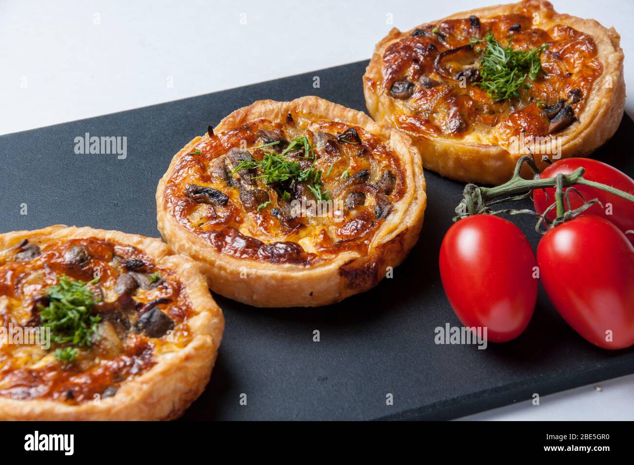 Gros plan de la plaque du petit déjeuner et des tomates fraîches. Tartes maison pour le petit déjeuner. Banque D'Images