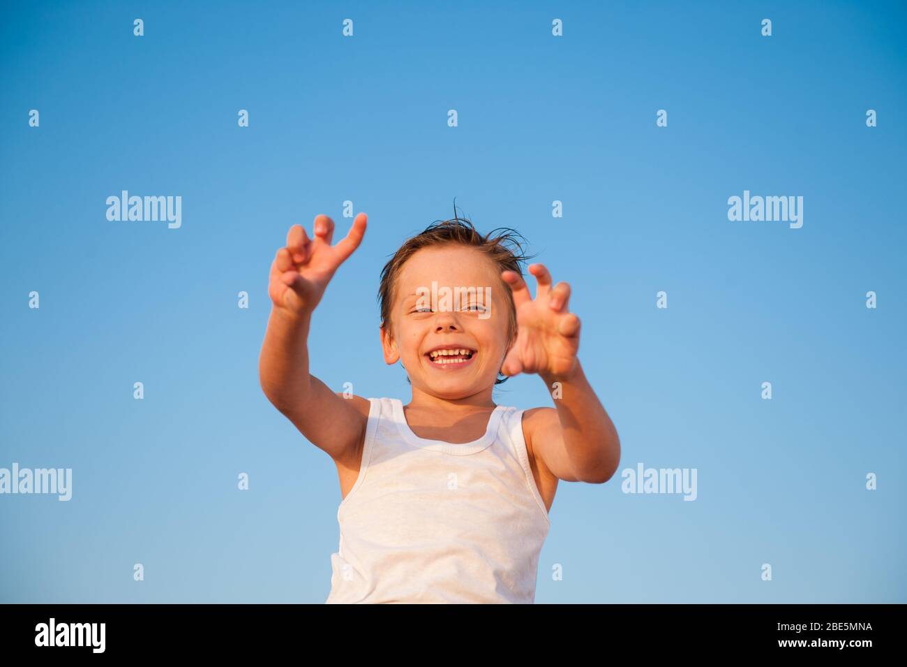 joyeux drôle petit enfant dans le réservoir blanc sur fond bleu ciel Banque D'Images