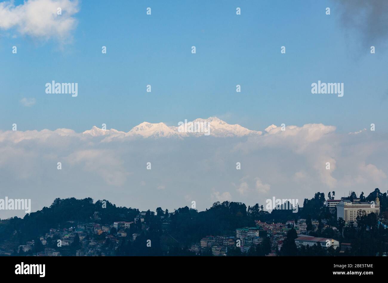 Belle vue sur le massif du Kangchenjunga qui monte sur des nuages bas sur un matin d'hiver partiellement nuageux à Darjeeling, Bengale occidental, Inde Banque D'Images