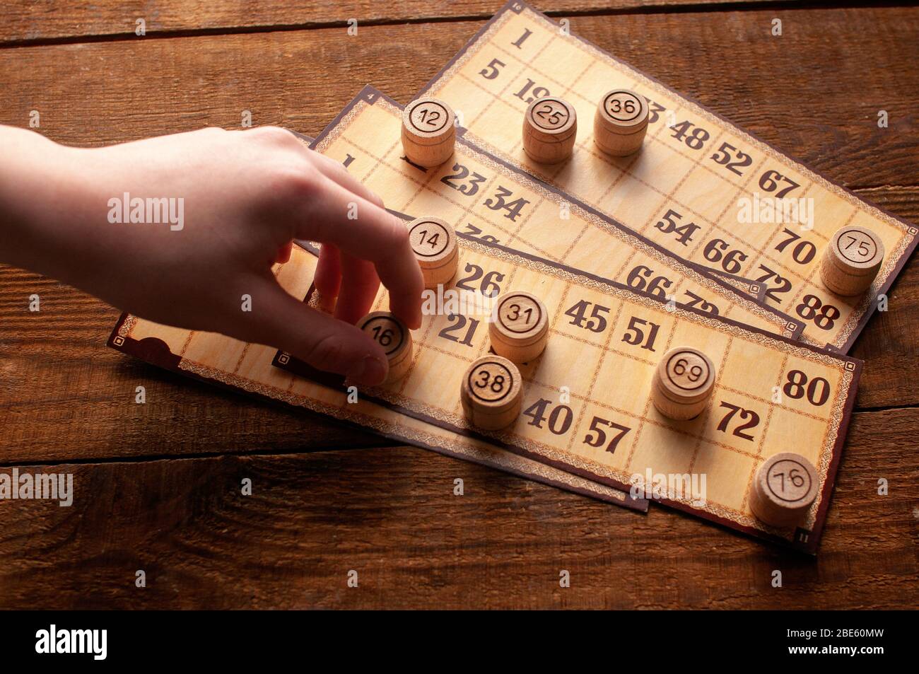 jeu de bingo lotto intéressant de famille vintage, la main tient un tonneau avec un nombre Banque D'Images