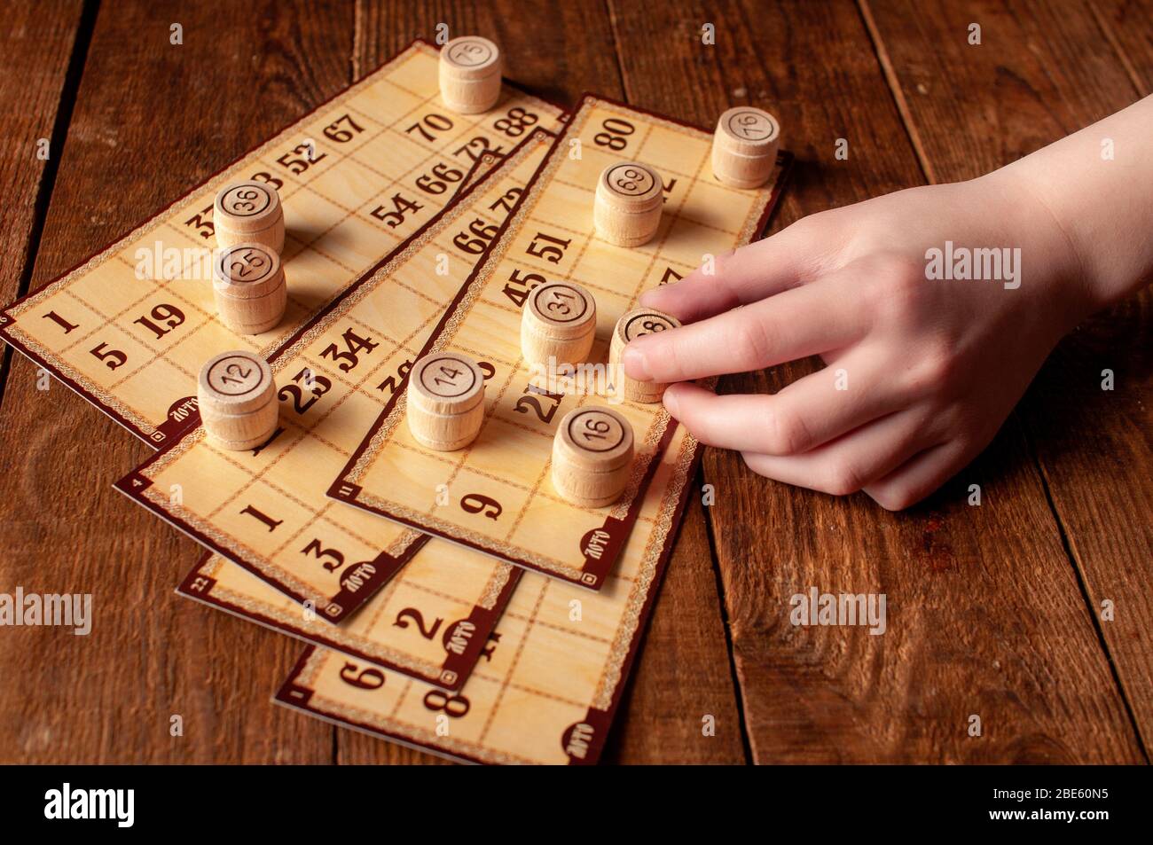 jeu de bingo lotto intéressant de famille vintage, la main tient un tonneau avec un nombre Banque D'Images