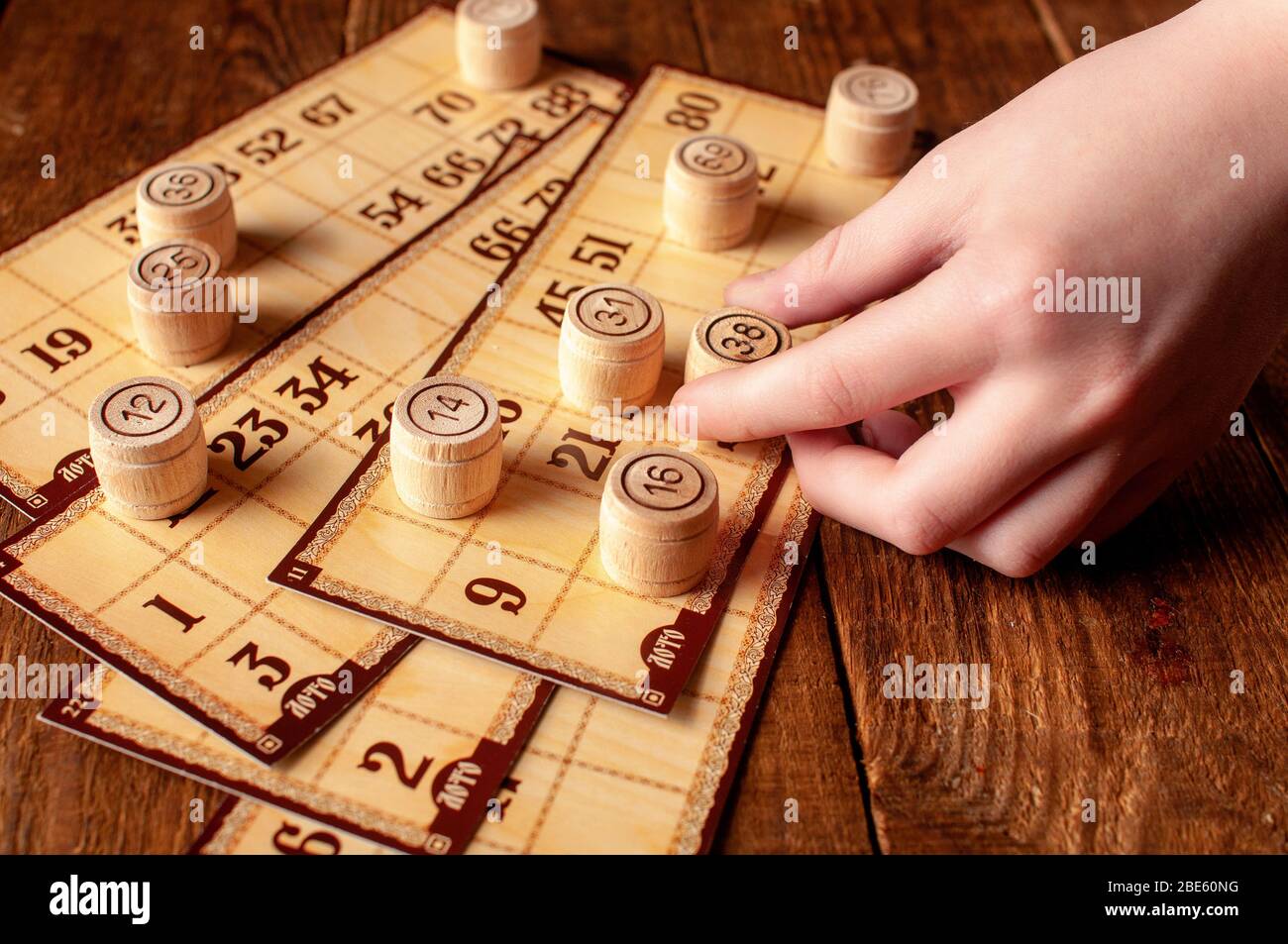 jeu de bingo lotto intéressant de famille vintage, la main tient un tonneau avec un nombre Banque D'Images