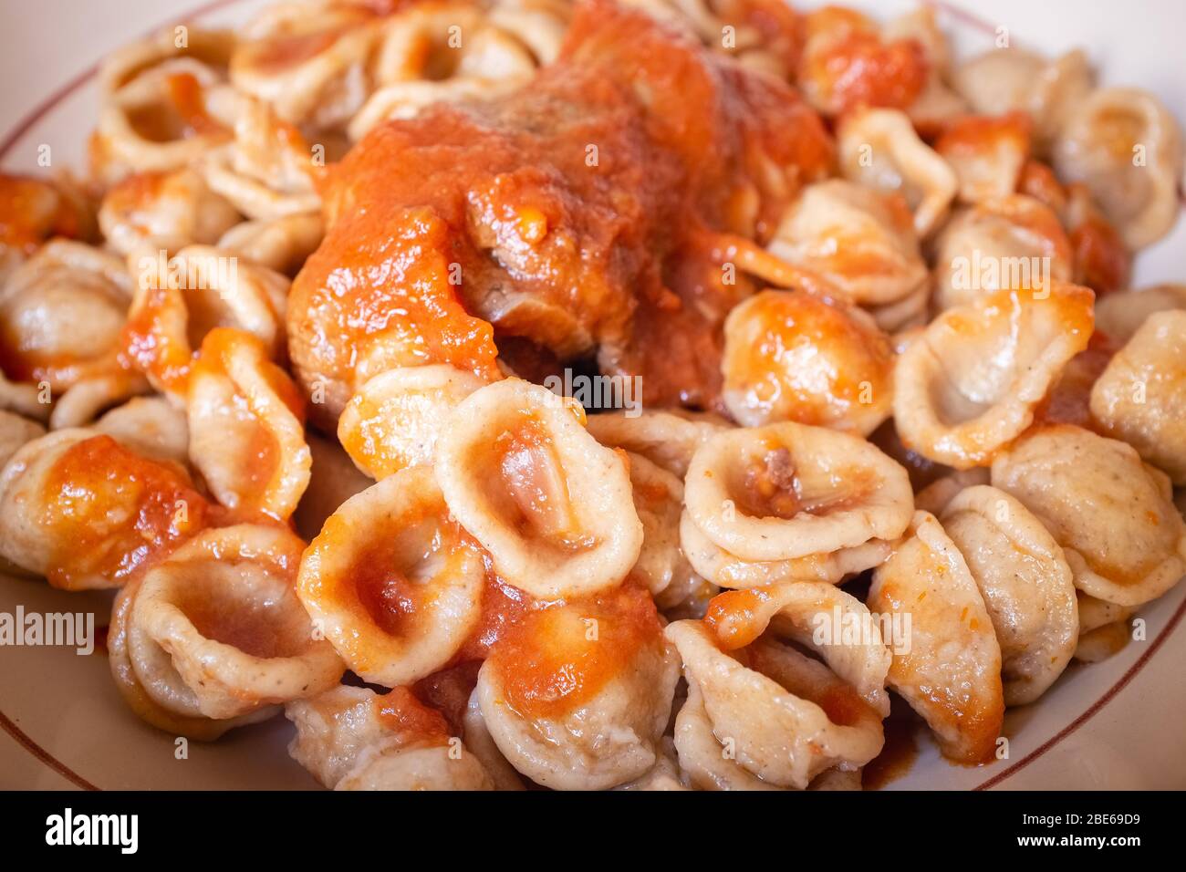 Délicieux plat de pâtes fraîches orecchietta et de la braciola de rouleau de viande avec sauce tomate. Cuisine typique d'Pouilles. Italie Banque D'Images