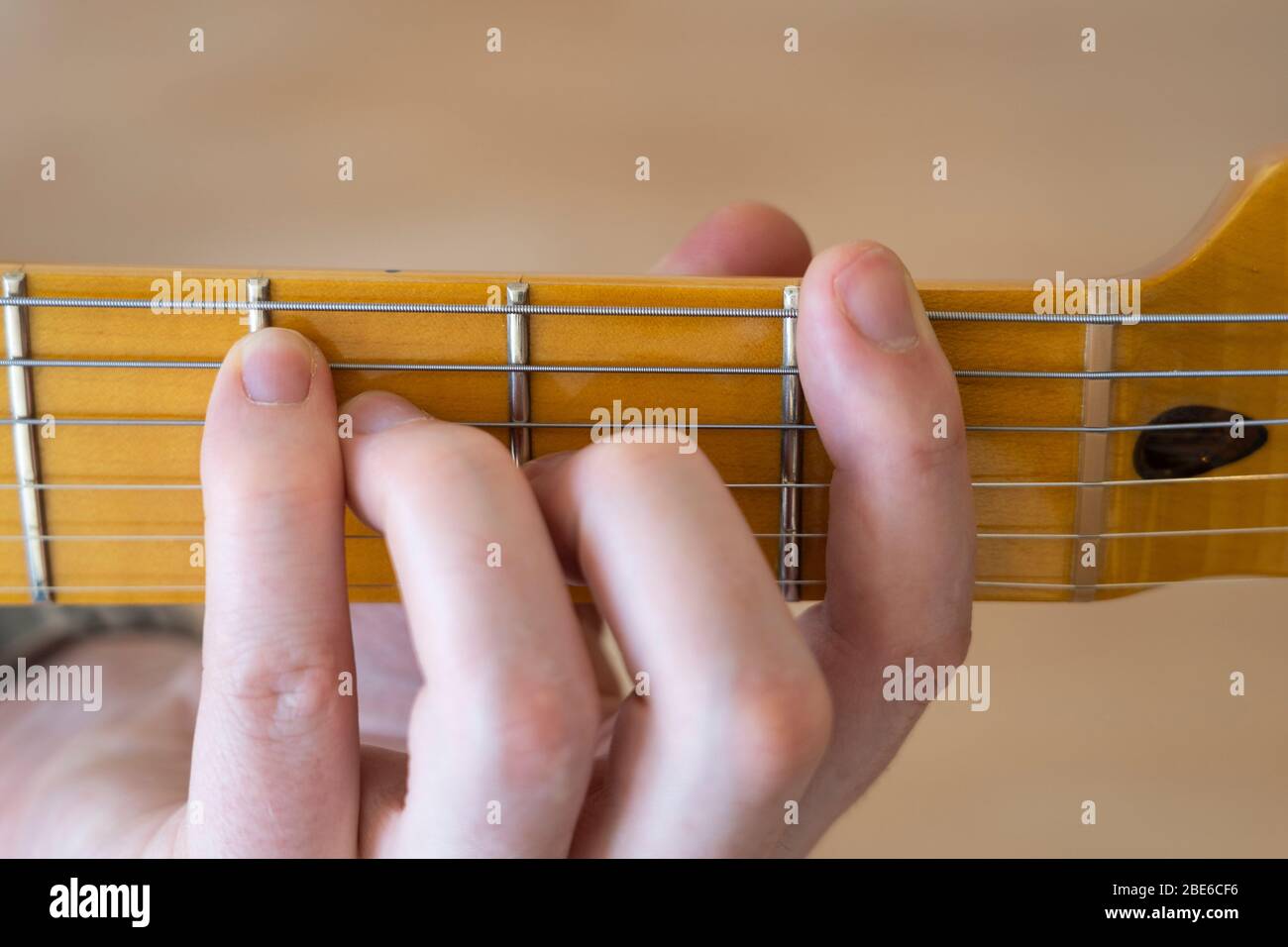 Jouer / démontrer / montrer un accord F sur une guitare électrique téléaster de joueur moderne d'aile avec un seul morceau de cou d'érable et de fretboard Banque D'Images