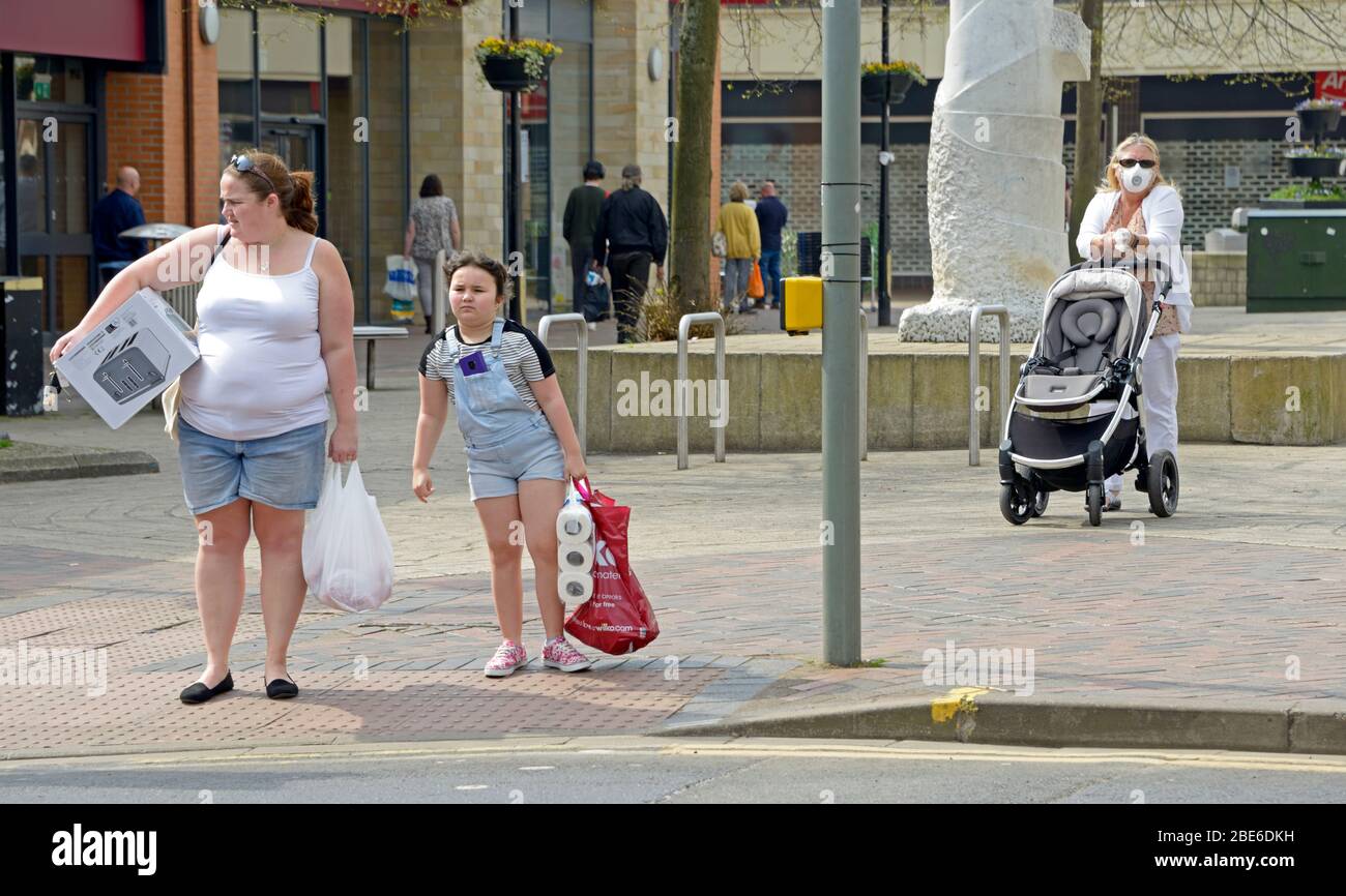 Shopping de mère et de fille, avec une dame en masque derrière, pendant le verrouillage du virus Corona Banque D'Images