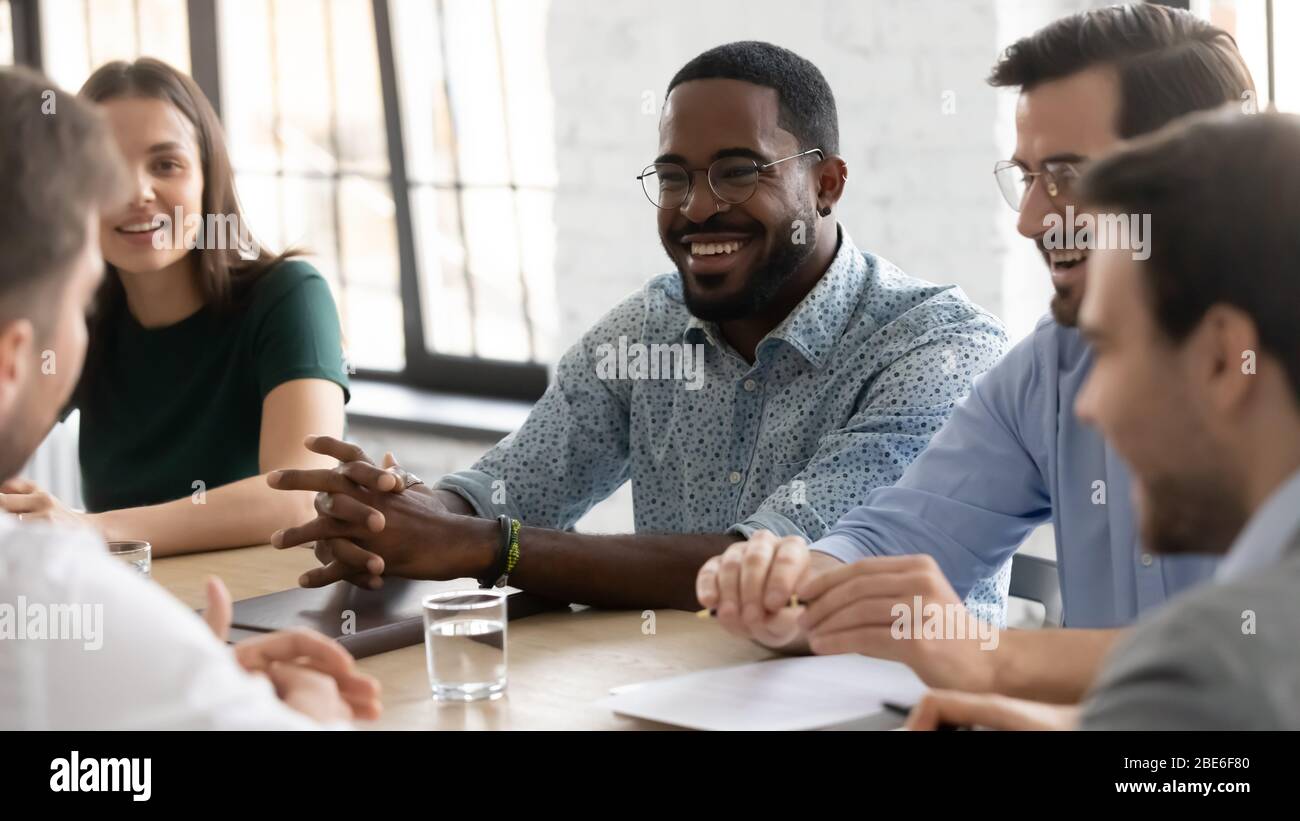 Des collègues multiethniques souriants remue-méninges pour discuter des idées au bureau Banque D'Images