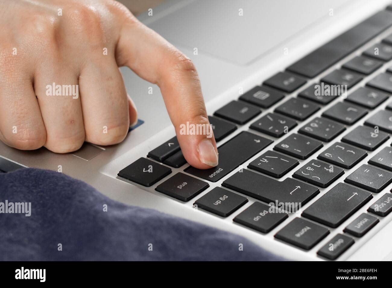 faire une pause pendant la quarantaine du coronavirus. Gros plan sur un doigt appuyer sur le bouton pause du clavier. Banque D'Images