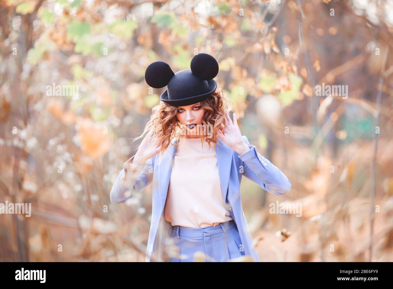 Jolie fille dans la rue dans un chapeau drôle. Congé d'automne. Les oreilles  de Mickey Mouse Photo Stock - Alamy