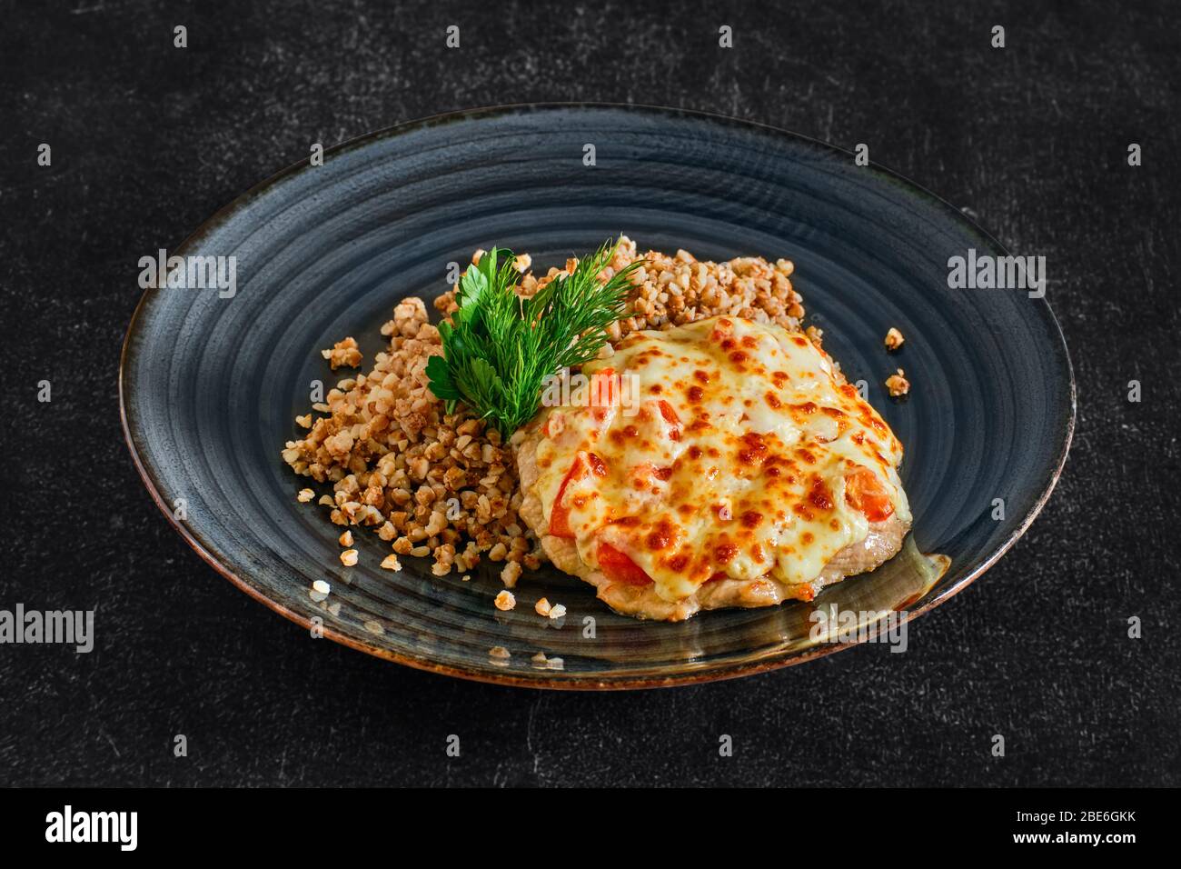 Viande de porc hachée, cuite au fromage et aux tomates, servie avec du porridge de sarrasin Banque D'Images