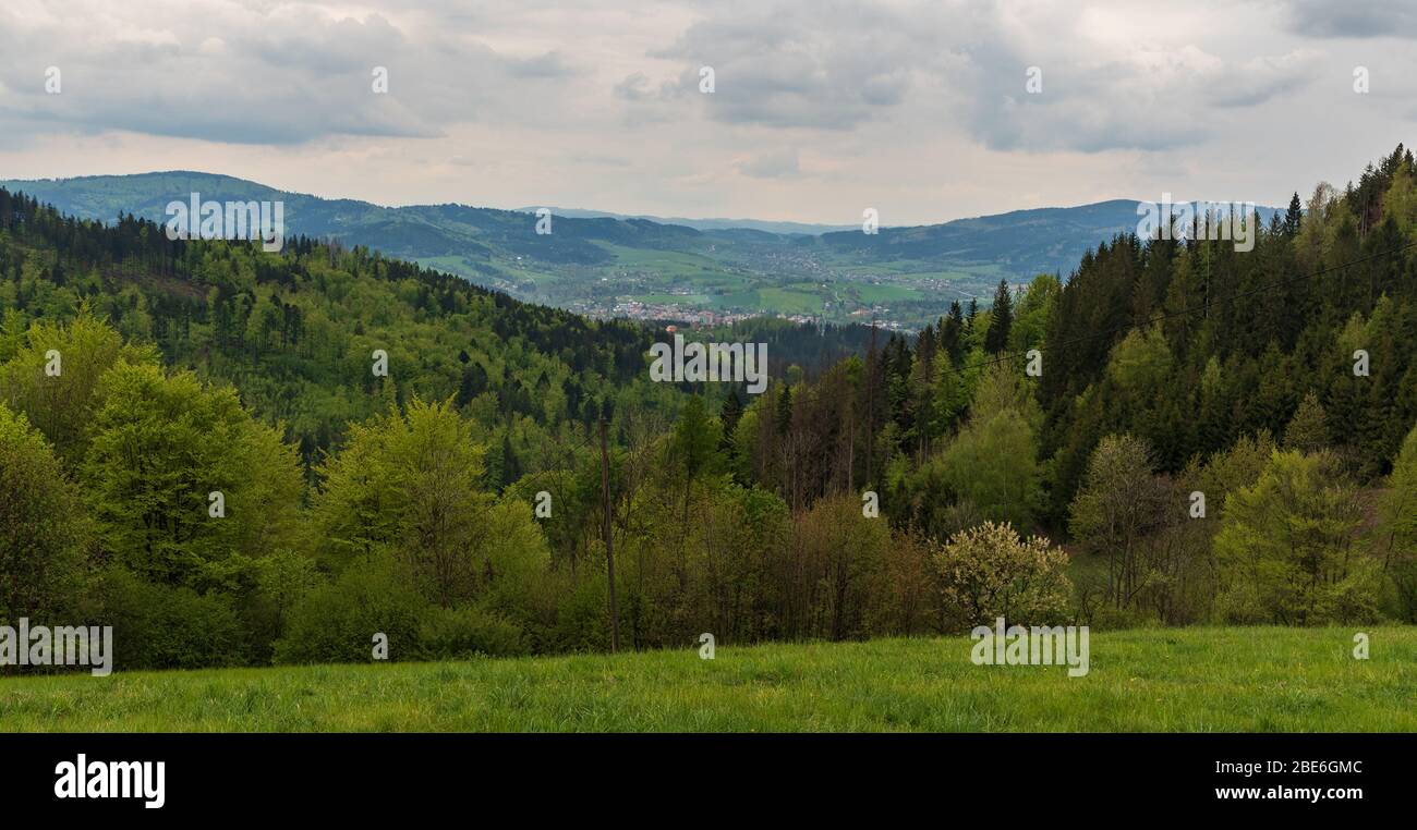 Vue de la prairie près de Zvonicka sv. Isidora au-dessus du village de Hradek nad Olsi en république tchèque avec des collines et la vallée de la rivière Olse avec la ville Jablunkov Banque D'Images