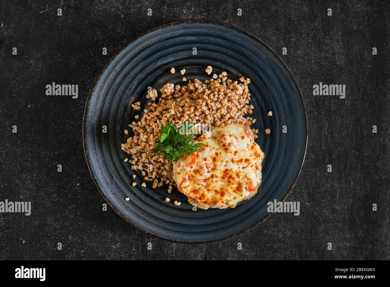 Vue de dessus de la viande de porc hachée cuite au fromage et à la tomate servie avec du porridge de sarrasin Banque D'Images