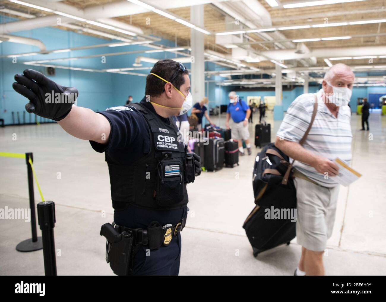 Les agents des douanes et de la protection des frontières des États-Unis portent un équipement de protection personnel pour se prémunir contre le coronavirus, car ils facilitent l'arrivée des passagers et des équipages qui débarquent des navires de croisière à Port Everglades le 3 avril 2020 à fort Lauderdale, en Floride. Banque D'Images