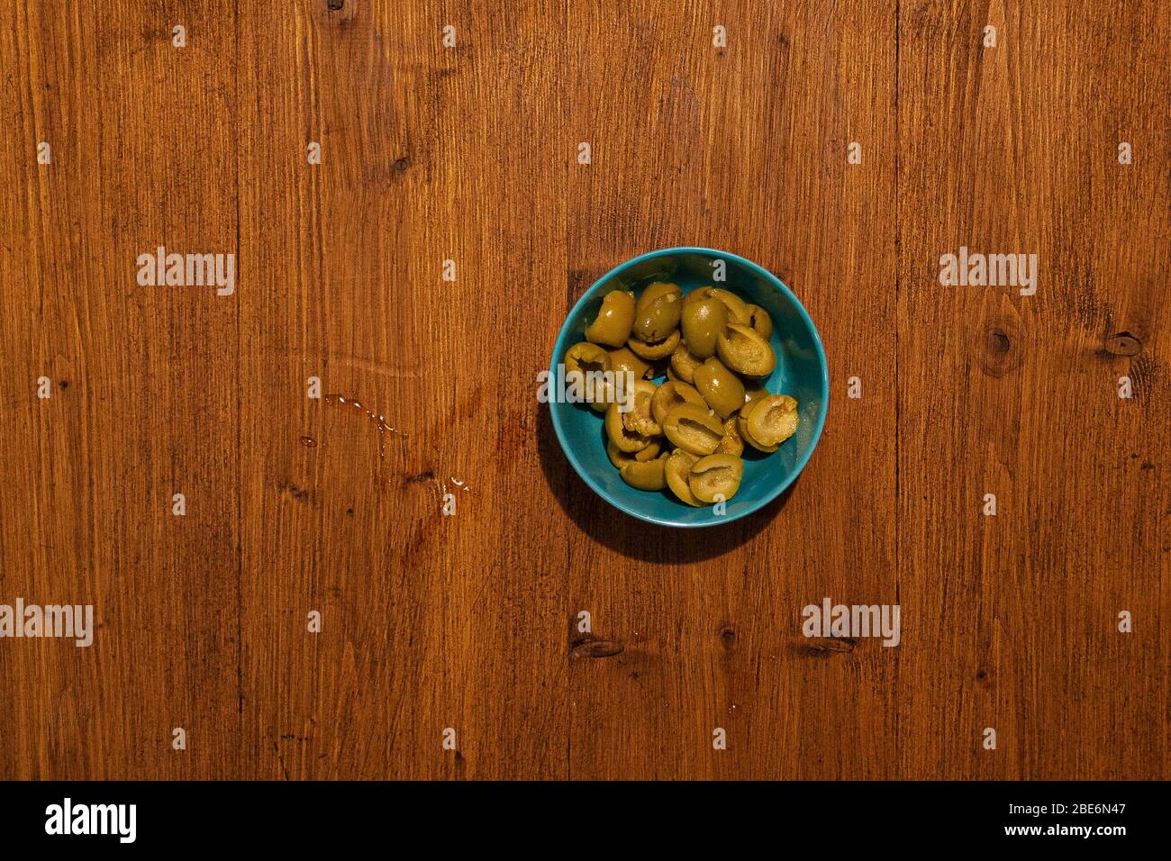 Vue de dessus de bol plein d'olives sur fond en bois Banque D'Images