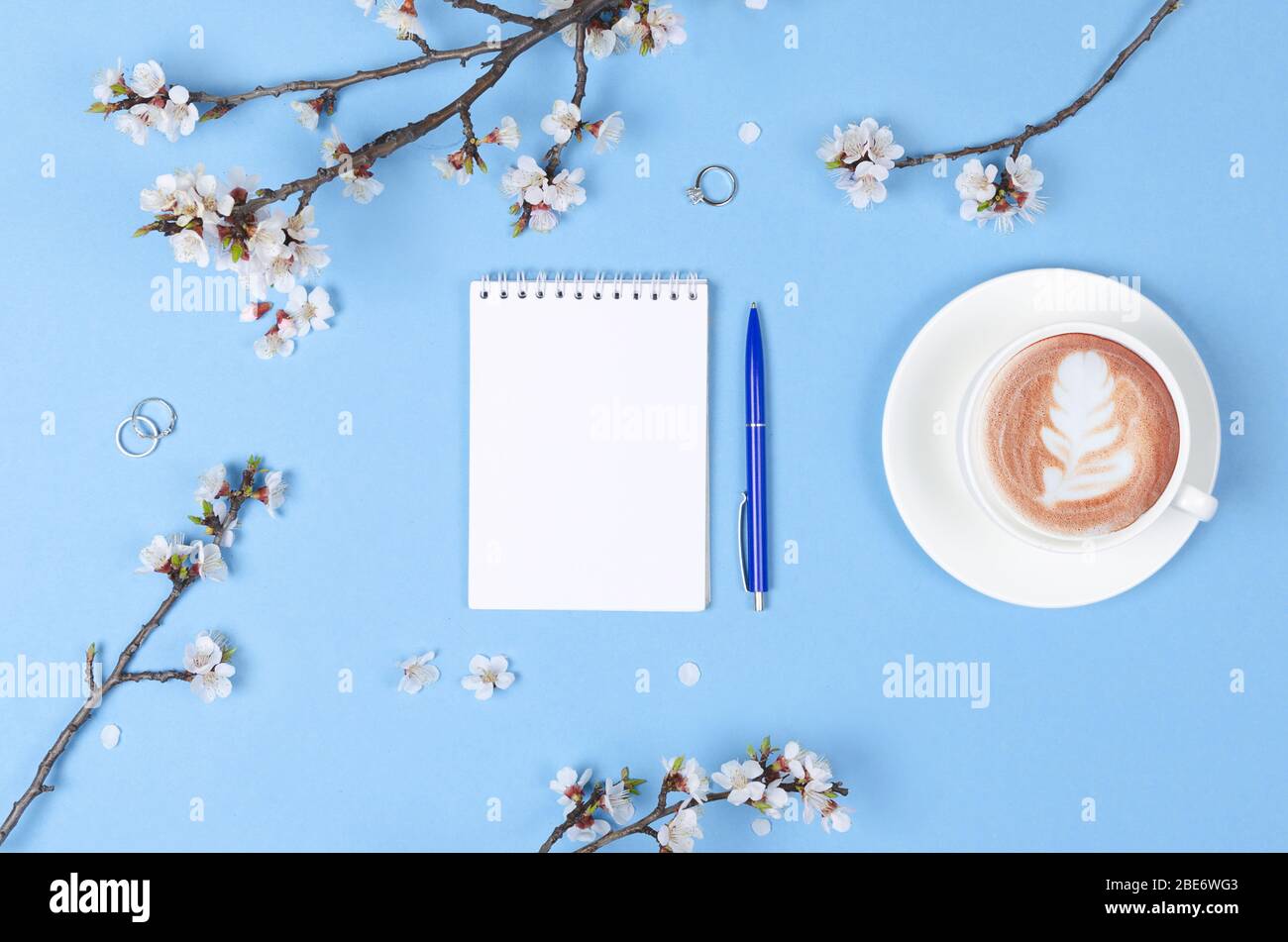 Liste de souhaits pour les plans futurs. composition de plat avec fleurs et bloc-notes et café avec art du café Banque D'Images