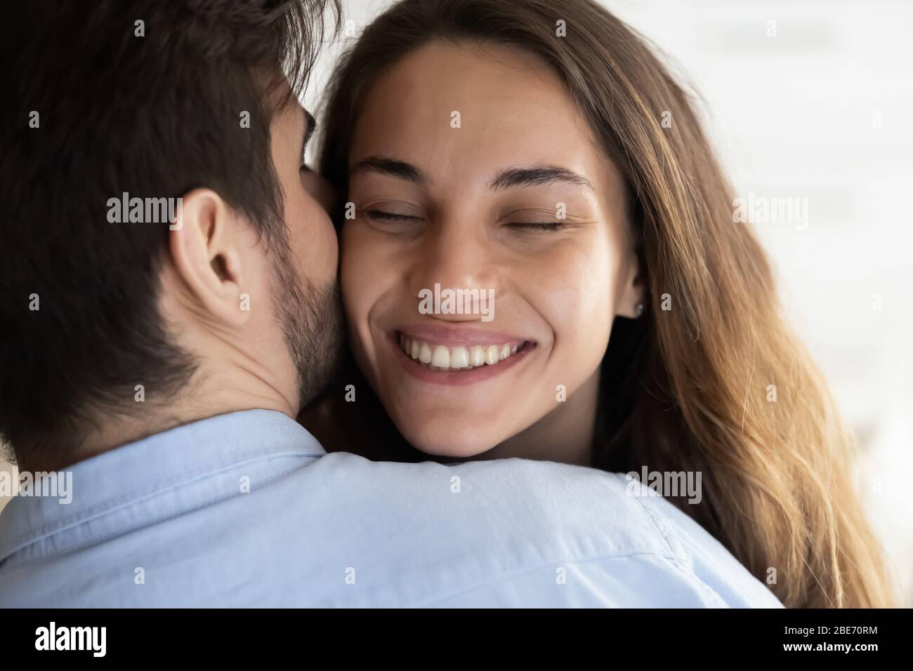 Affectueux homme affectueux épouse en bas de la tasse, chuchotant des mots doux dans l'oreille. Banque D'Images