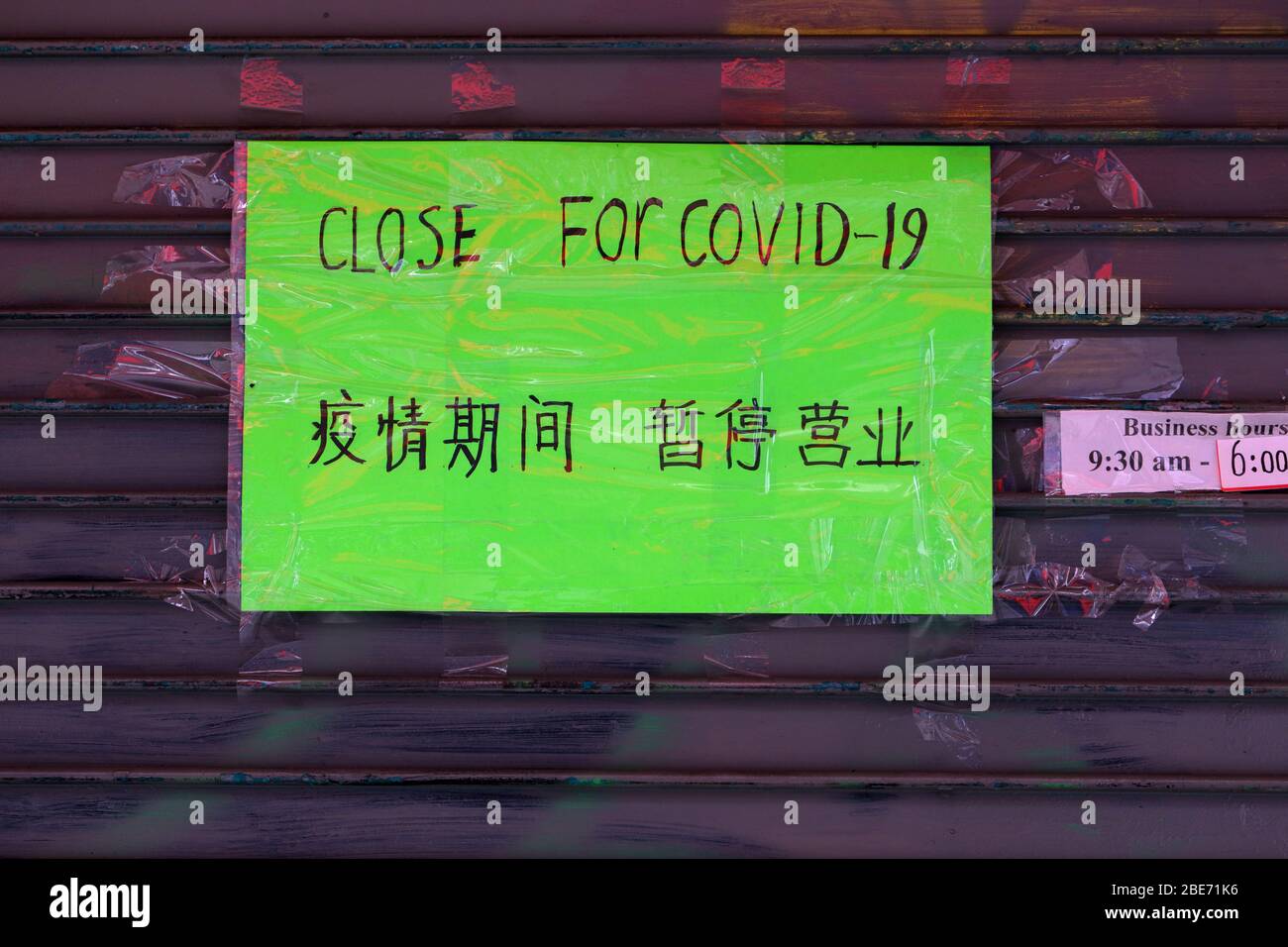 Un panneau en anglais et en chinois simplifié sur un magasin fermé à Manhattan Chinatown fermé pour une pandémie de coronavirus COVID-19 Banque D'Images