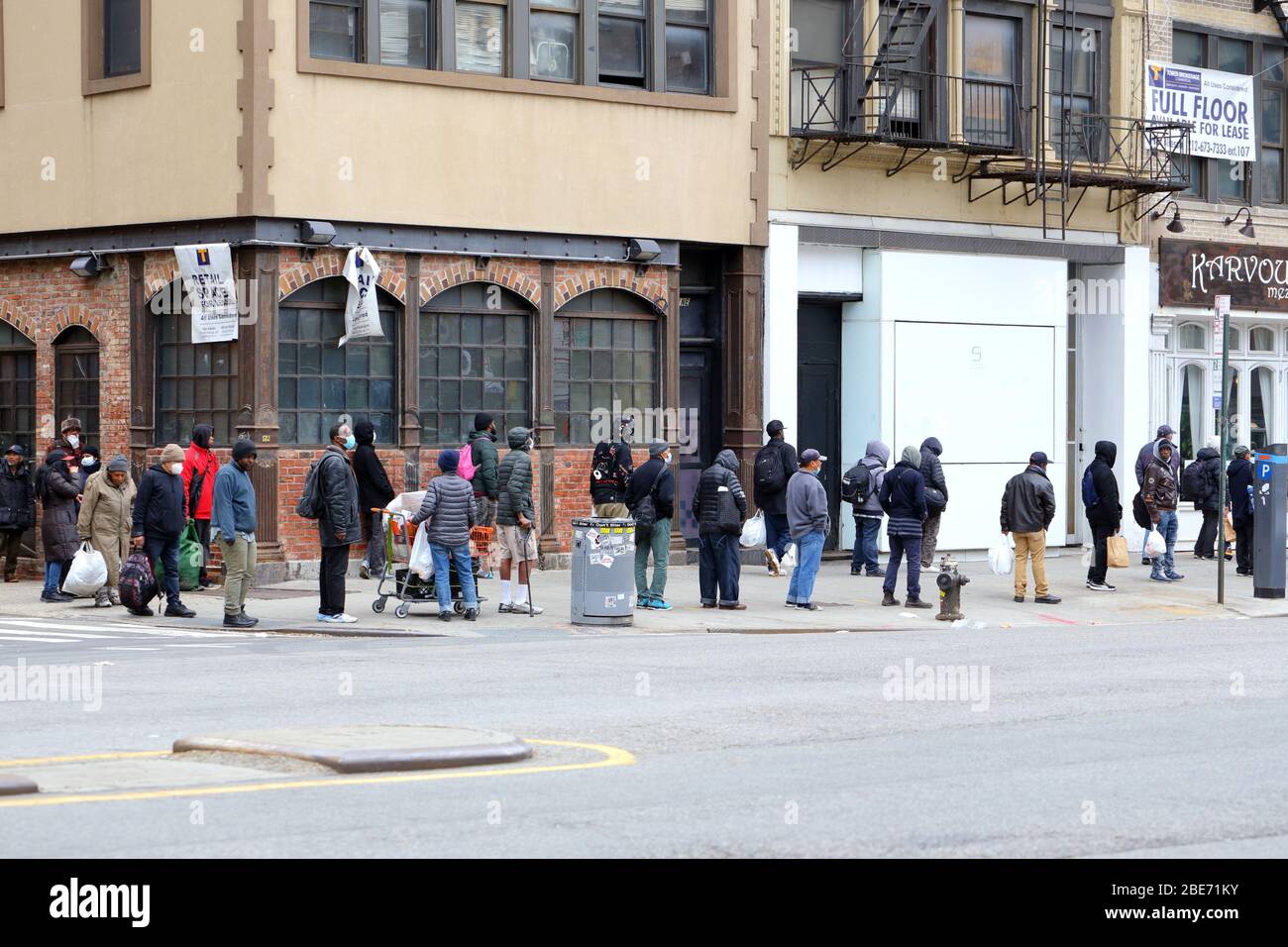Les gens qui font la queue pour un déjeuner de Pâques à la mission Bowery à New York pendant le coronavirus... PLUS D'INFORMATIONS POUR LA LÉGENDE COMPLÈTE Banque D'Images