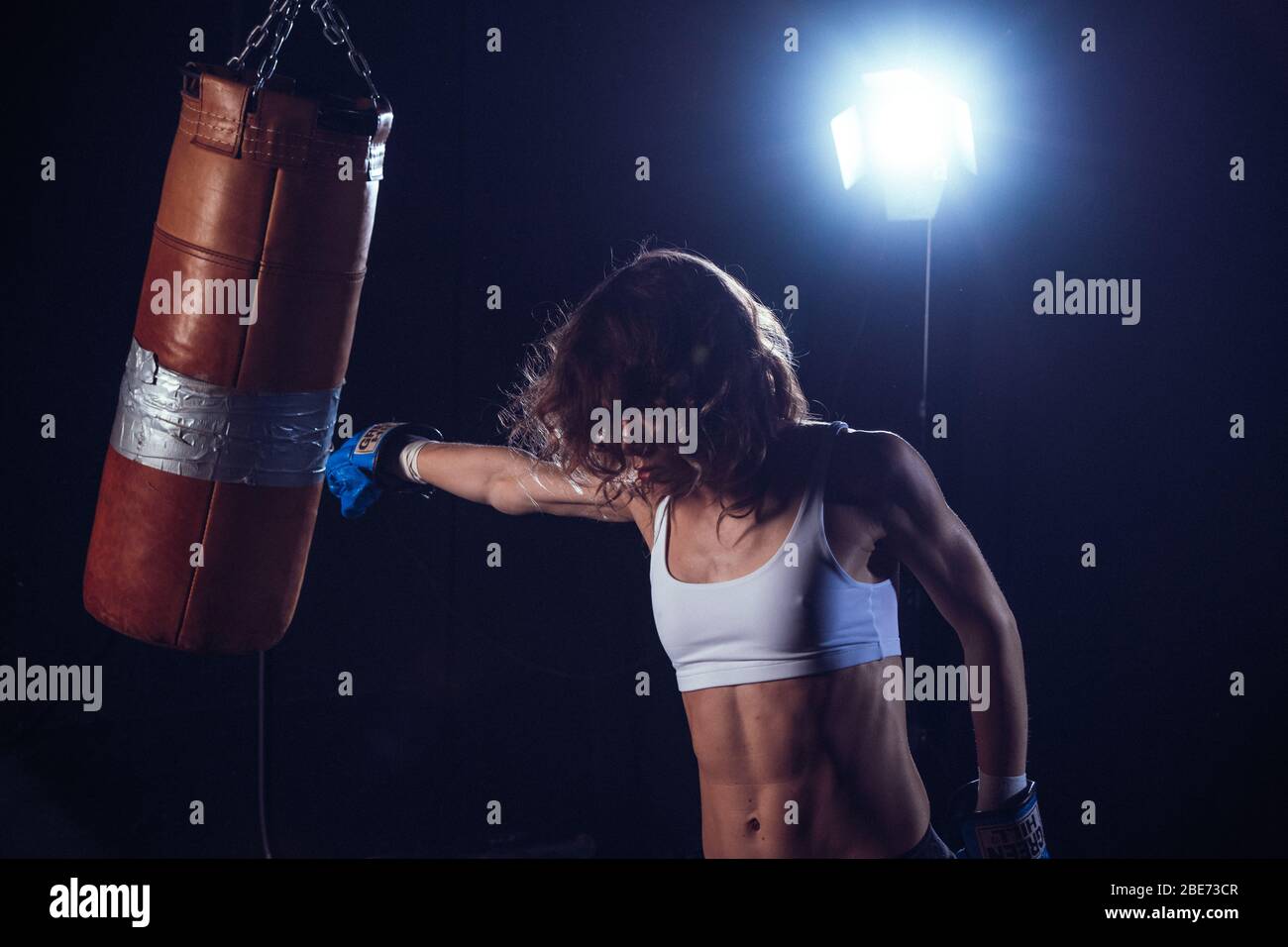 Jeune boxer sexy pour femme. Arts martiaux ou auto-défense. Boxer de sport femme dans des gants de boxe fait un coup de pied . Entraînement de fille de forme physique kick boxe. Boxe trai Banque D'Images