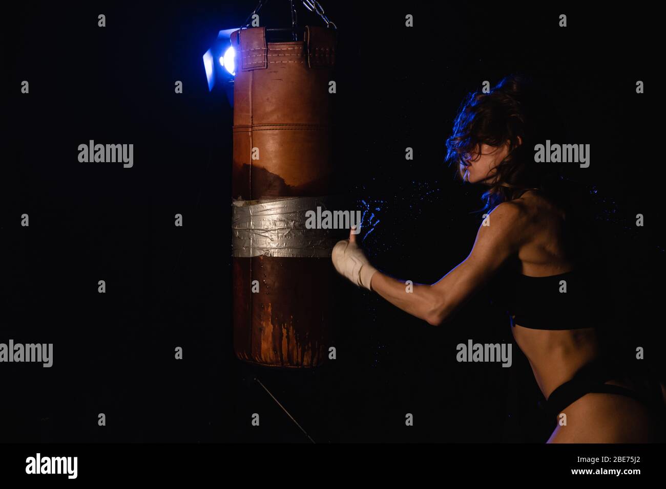 Jeune boxer sexy pour femme. Arts martiaux ou auto-défense. Boxer de sport femme dans des gants de boxe fait un coup de pied . Entraînement de fille de forme physique kick boxe. Boxe trai Banque D'Images