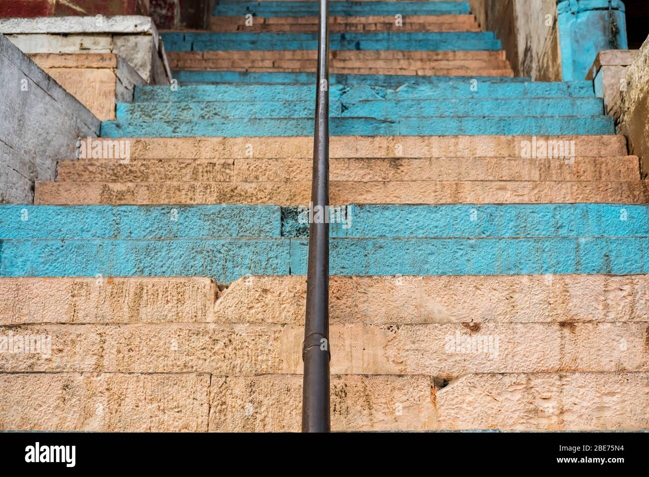 Escaliers en pierre peints en bandes bleues menant au Ganga rivière à Varanasi Banque D'Images
