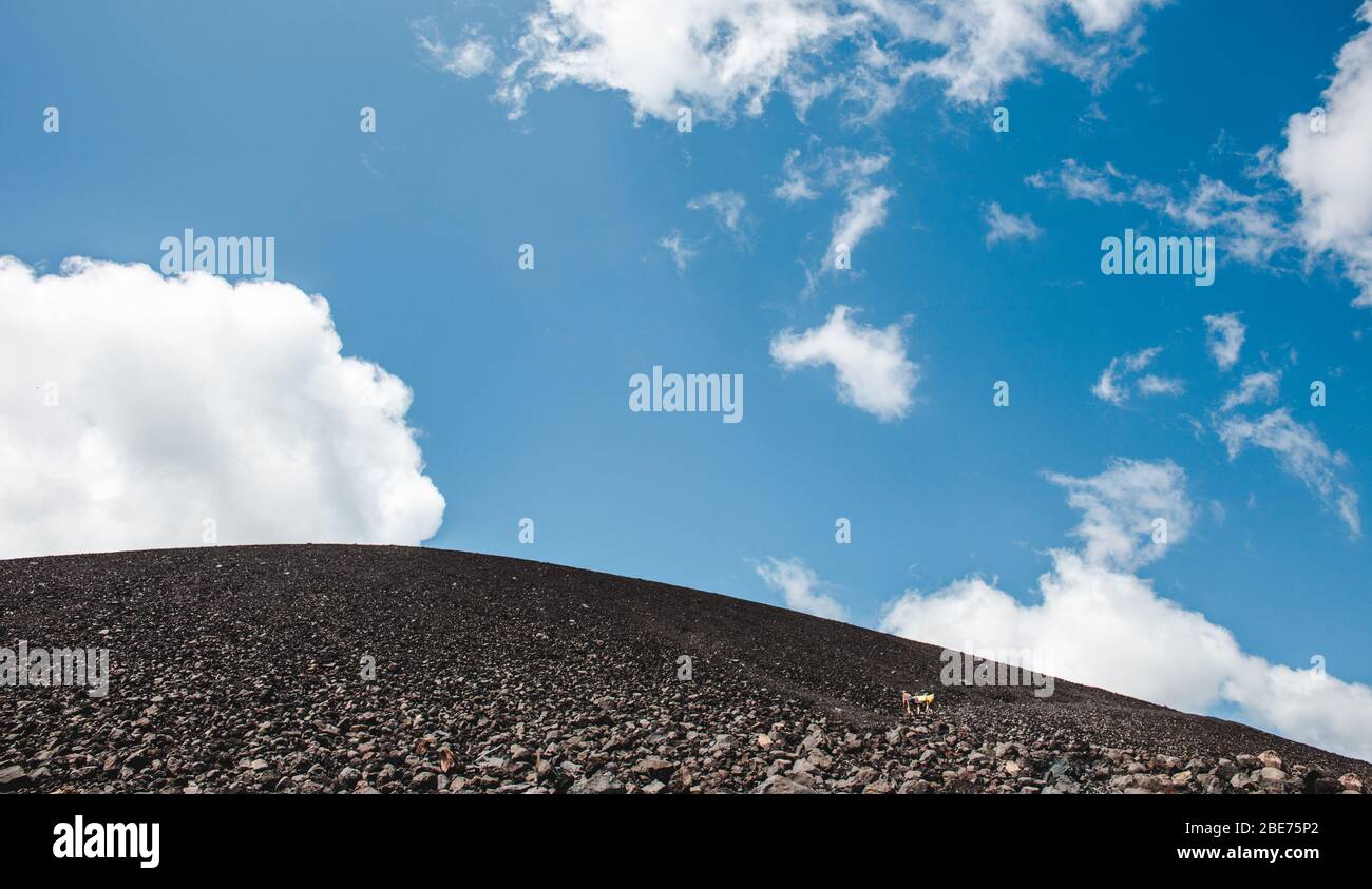 Les touristes qui font de la randonnée dans le sable noir de Cerro Negro pour monter à bord du volcan - une excursion populaire près de Leon, Nicaragua Banque D'Images