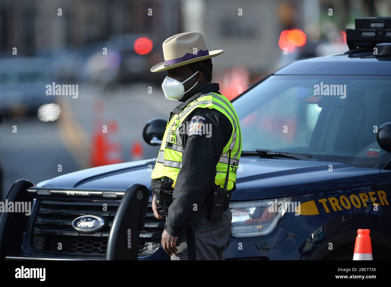 New York City, États-Unis. 12 avril 2020. Un Trooper de l'État de New York se tient au carrefour de Beverly Road et de Bedford Avenue pour surveiller la circulation près du site d'essai COVID-19 installé dans le parking Sears de la section Flatbush du quartier de New York City Borough de Brooklyn, NY, le 12 avril 2020. Bien que les cas de coronavirus, les admissions et les hospitalisations en USI aient chuté dans tout l'État de New York, le nombre de morts n'en a pas. (Anthony Behar/Sipa USA) crédit: SIPA USA/Alay Live News Banque D'Images