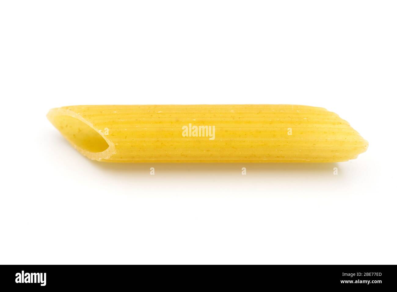 Pâtes maison de la penne sur fond blanc isolé dans macro vue rapprochée. Penne ressemble à un tube et ont une couleur jaune. Les pâtes sont de délicieux tr italien Banque D'Images