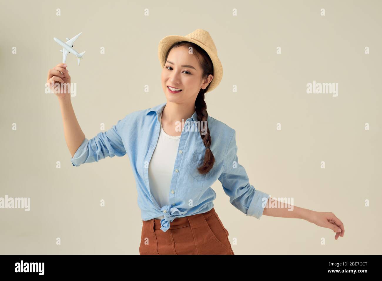 Portrait de la jeune femme heureuse tenant des avions à réaction sur fond blanc. Bannière publicitaire pour les entreprises de transport Banque D'Images