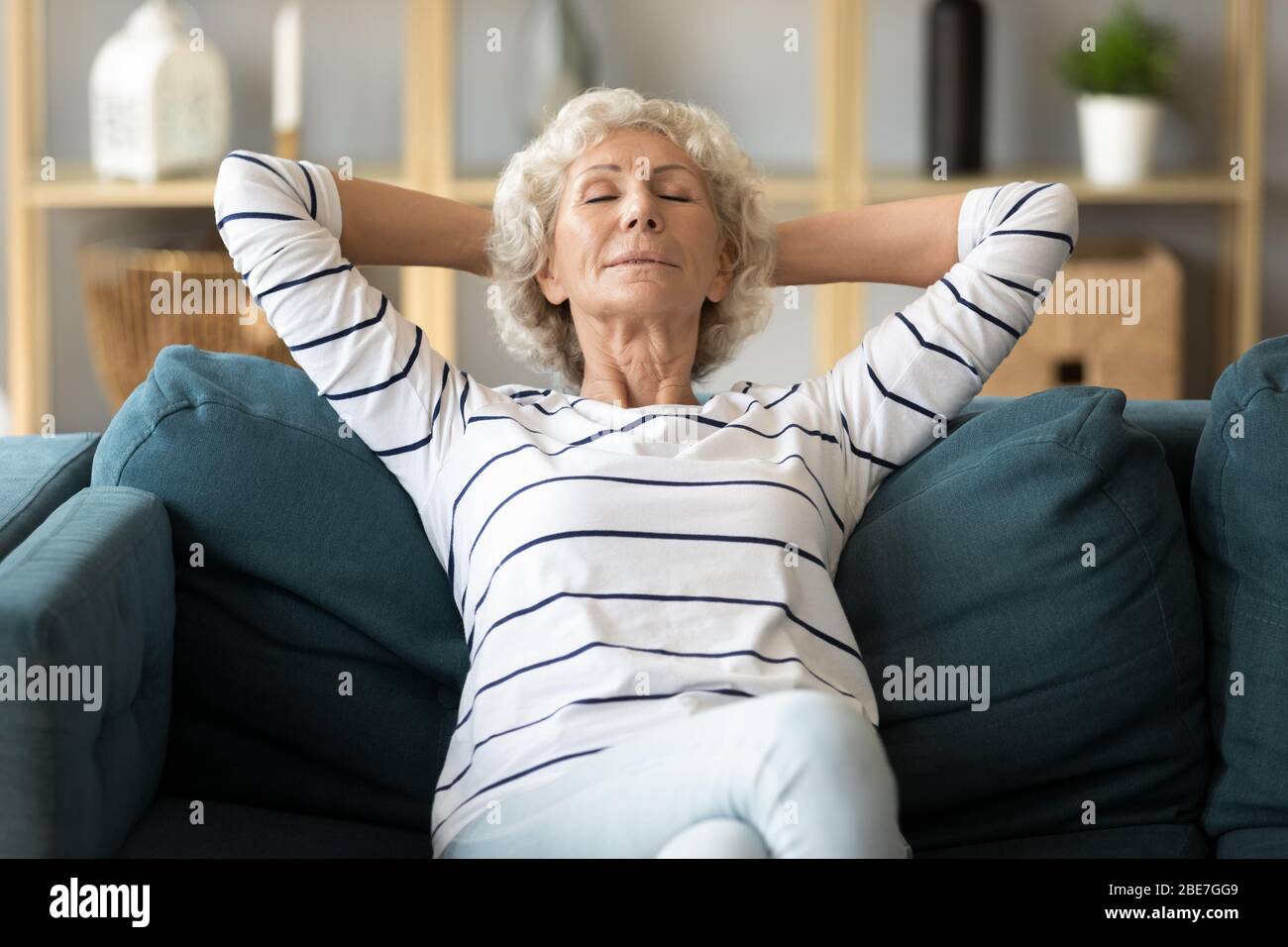 Calme et calme, la femme âgée penchait sur le canapé Banque D'Images