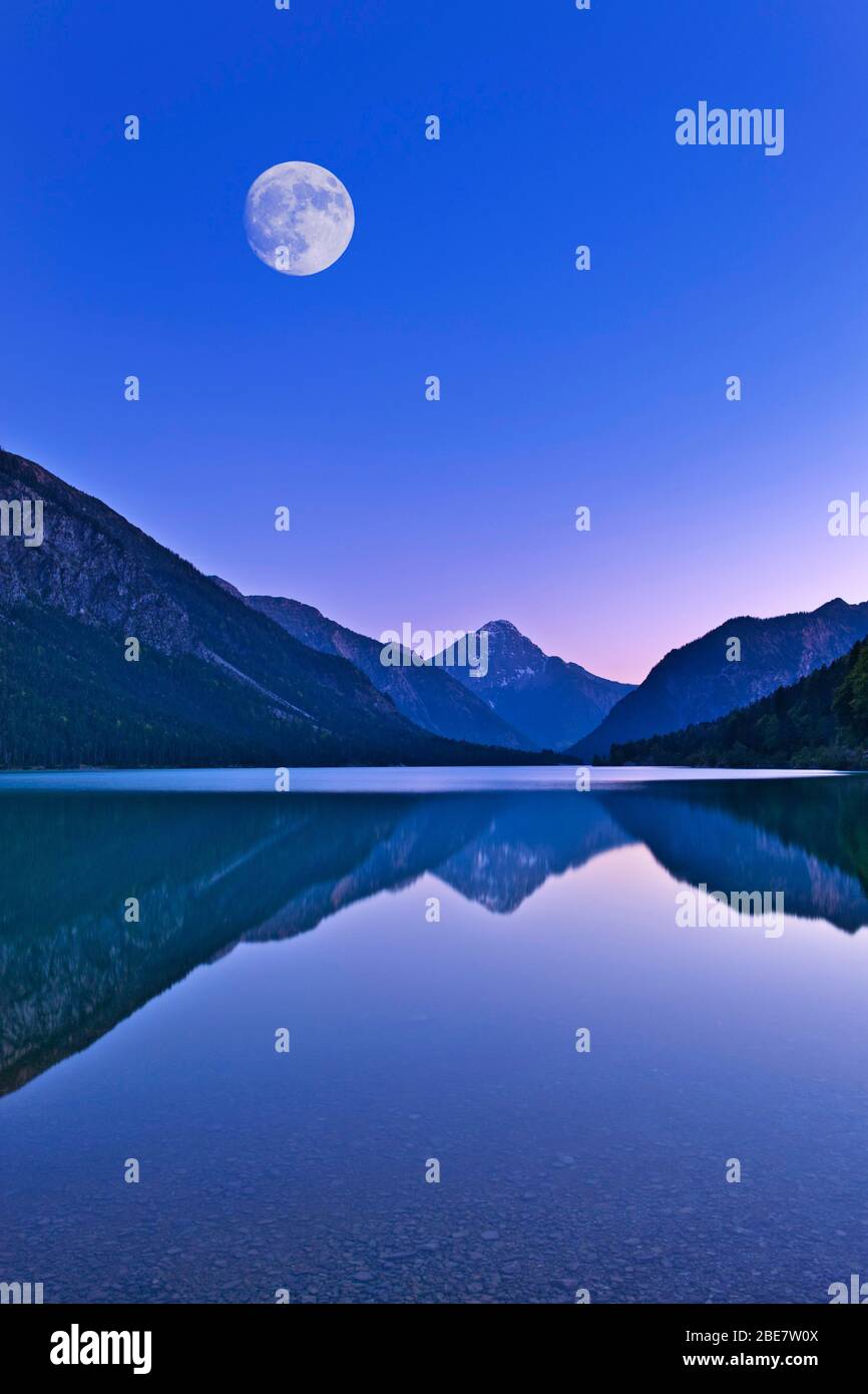 Lac Plansee avec pleine lune, ambiance de soirée, Alpes d'Ammergau, derrière la montagne Thangeller dans les Alpes de Lechtal, Tyrol, Autriche Banque D'Images