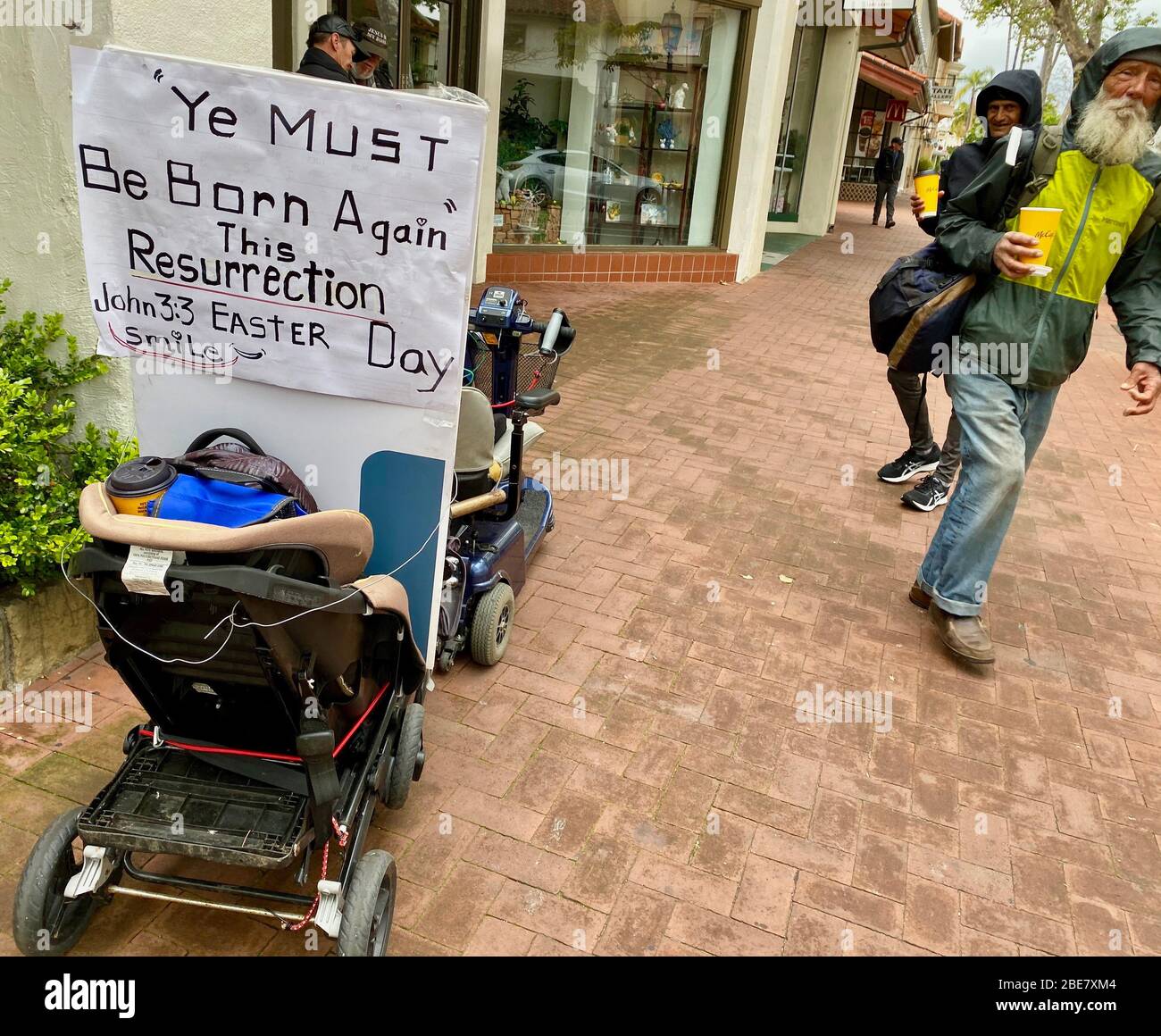 Santa Barbara, Californie, États-Unis. 12 avril 2020. Vous devez être né de nouveau cette résurrection, Smile' lit le signe sur une voiture de bébé servant comme un buggy sans abri manÃs le dimanche de Pâques sur State Street à Santa Barbara, CA. La situation est devenue désaseuse, puisque le Covid-29 se propage parmi les sans-abri, tuant déjà une victime et se propageant rapidement parmi le reste de la population. Crédit: Amy Katz/ZUMA Wire/Alay Live News Banque D'Images