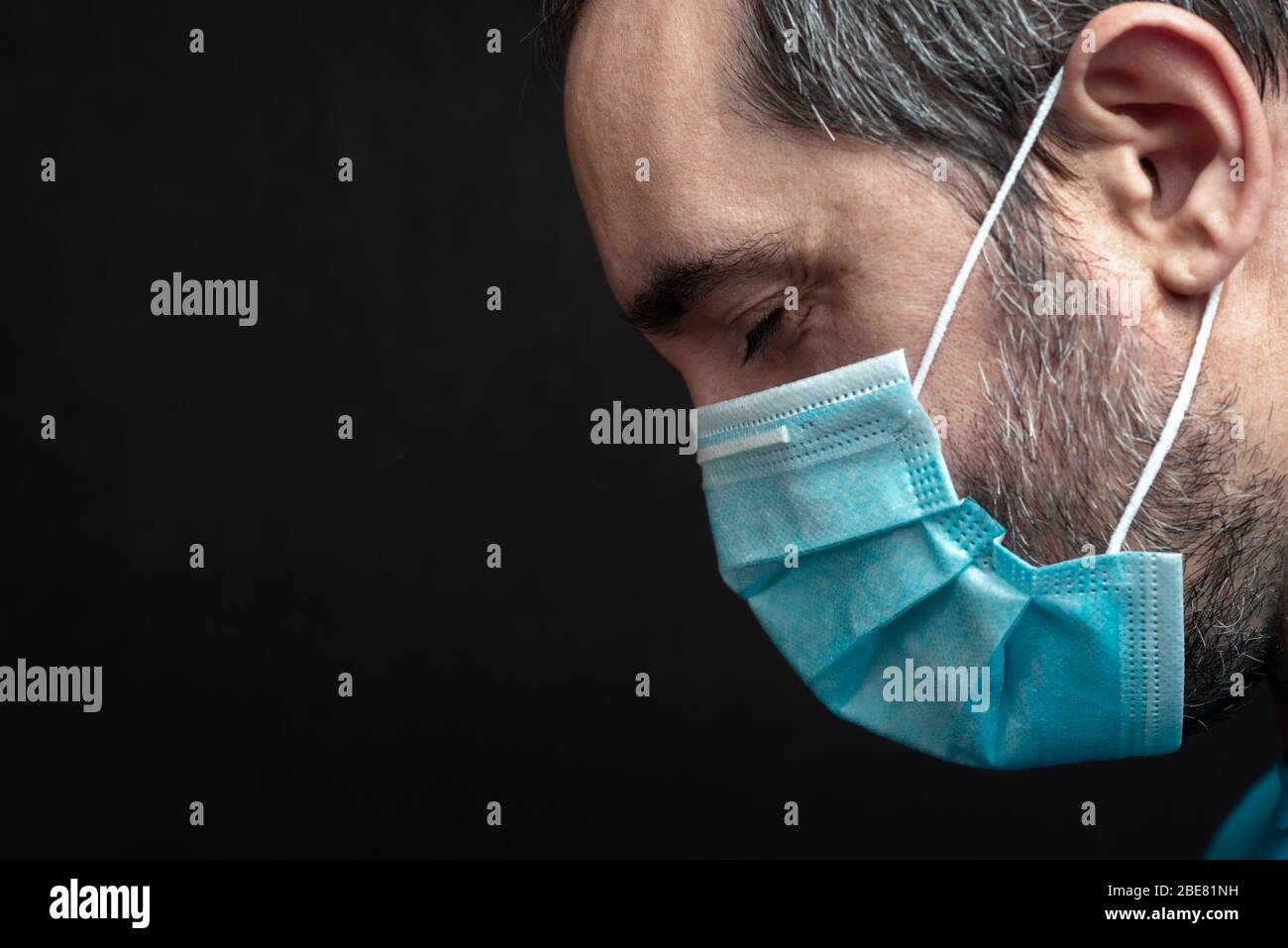 portrait latéral d'un homme avec un masque médical et yeux rapprochés sur un fond noir Banque D'Images