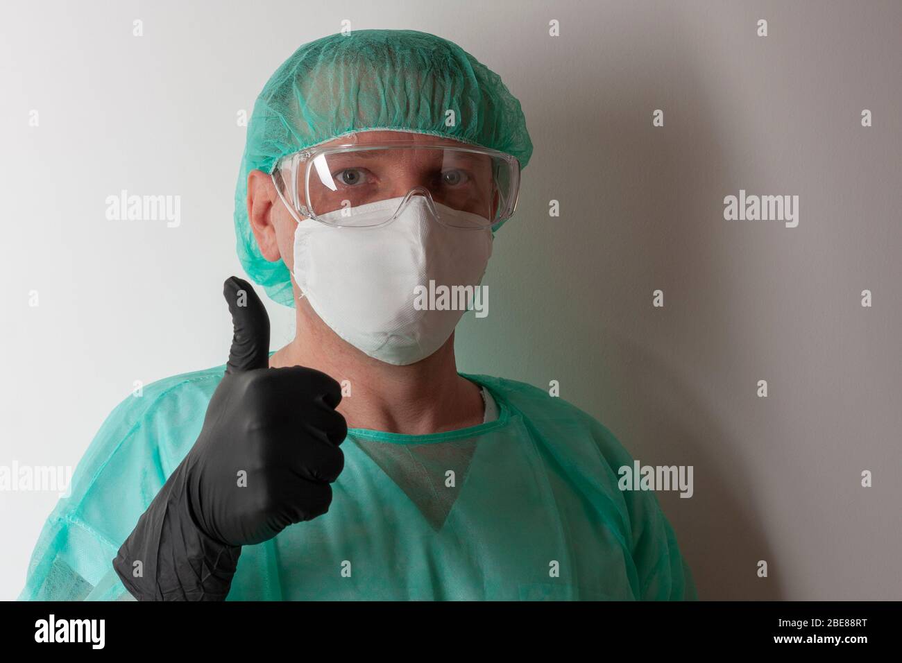 Infirmière mâle, avec lunettes de protection en plastique et masque  respiratoire ffp2, capuchon, robe, gants, avec équipement de protection  personnel pour protéger contre le vir Photo Stock - Alamy
