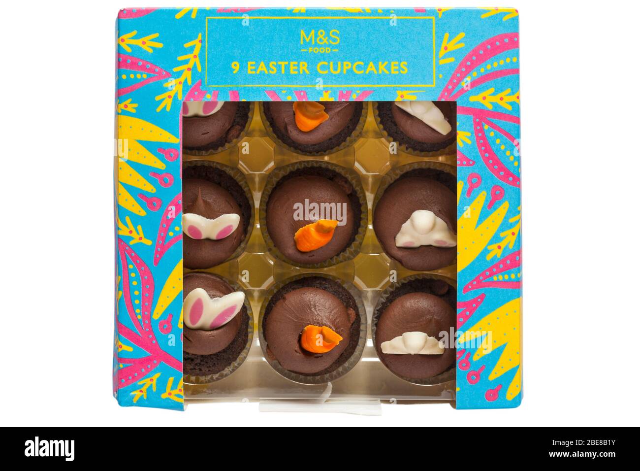 Boîte de 9 M&S Cupcakes de Pâques isolés sur fond blanc - mini cupcakes de chocolat avec crème de chocolat et décorations de Pâques Banque D'Images