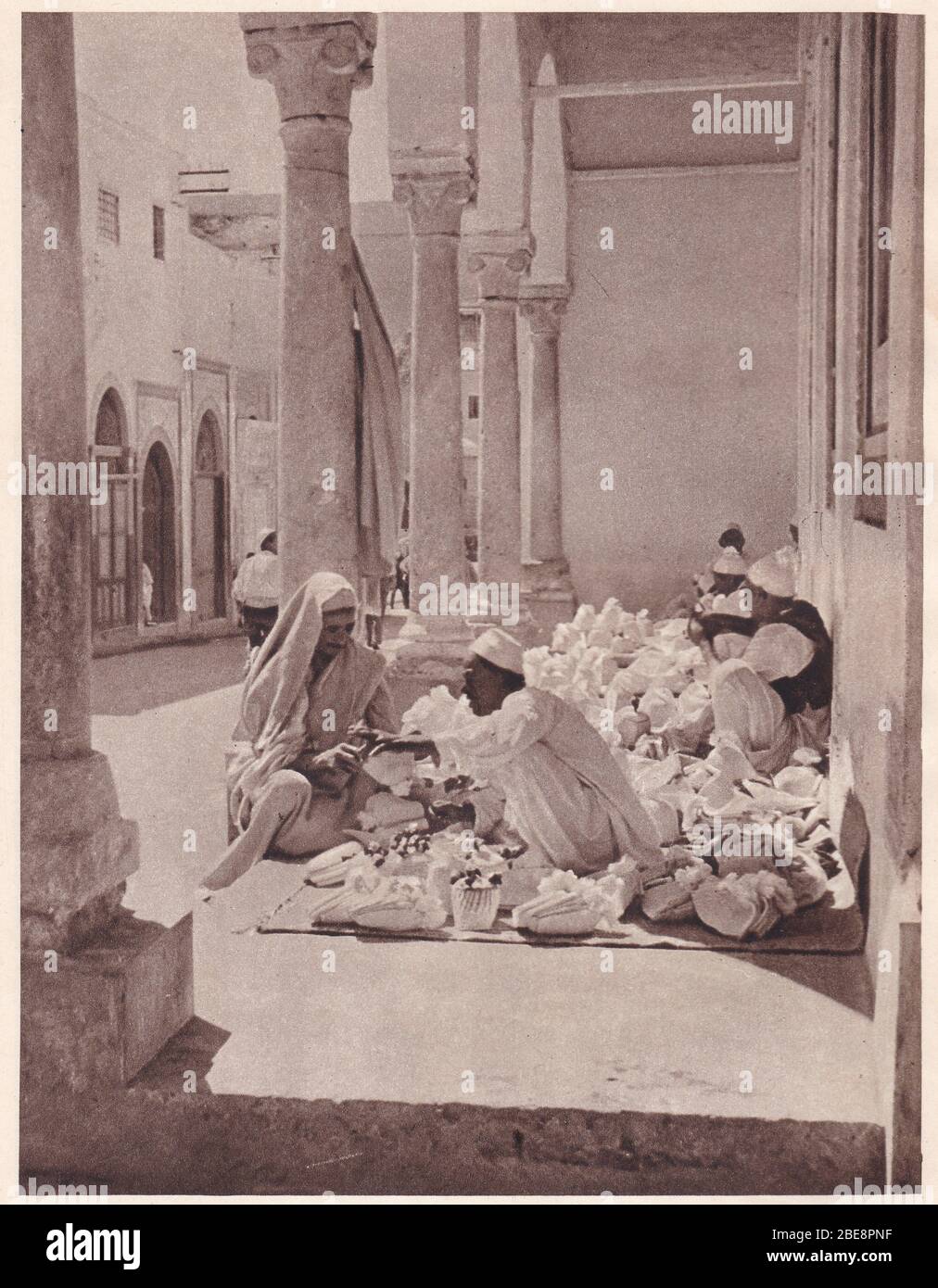 Photo noir et blanc des marchands de carpettes vendant leurs marchandises à Tripoli des années 1930. Banque D'Images