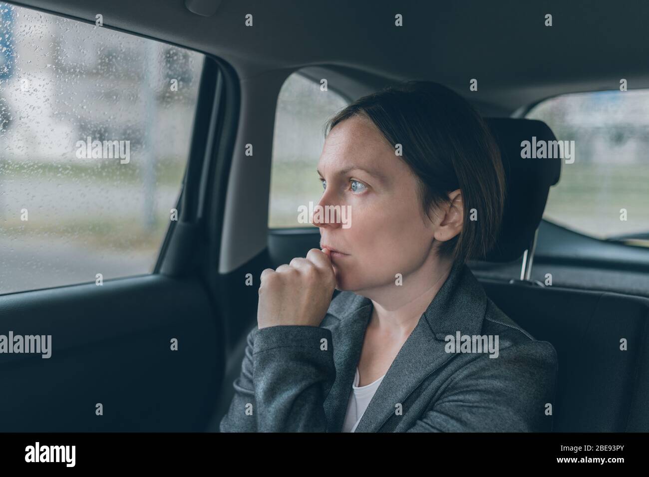 Femme d'affaires inquiète assise sur le siège de dossier de voiture, regardant nerveux et anxieux Banque D'Images