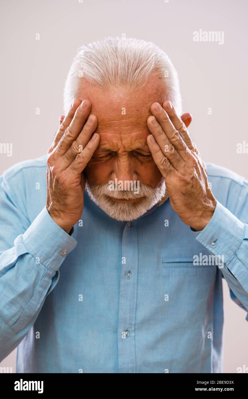 Portrait de l'homme senior qui a mal à la tête. Banque D'Images