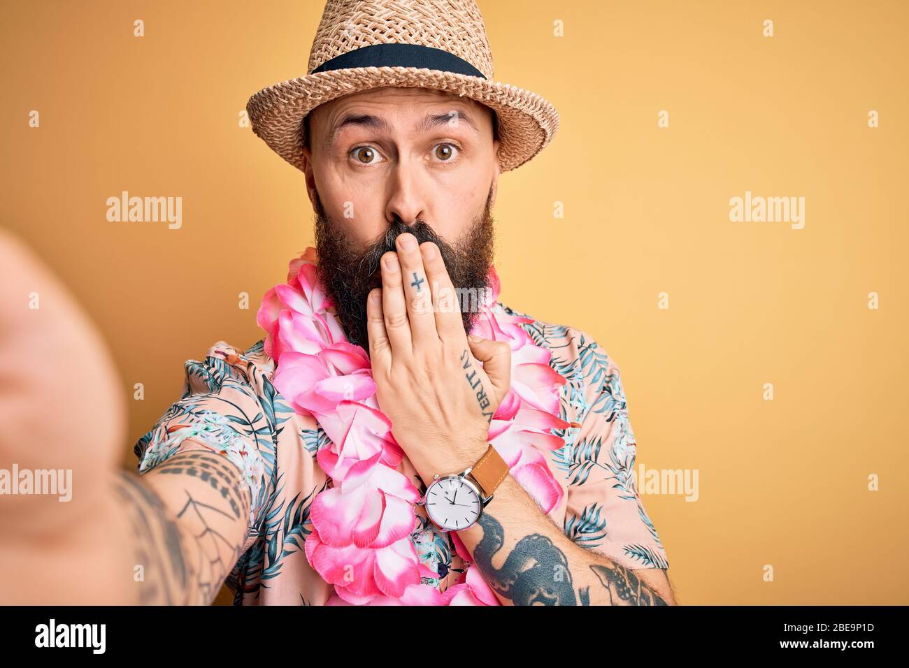 Beau homme chauve avec barbe et tatouage en vacances portant chapeau d'été  et la bouche de couverture hawaïenne avec la main choquée avec honte pour  erreur, expressi Photo Stock - Alamy