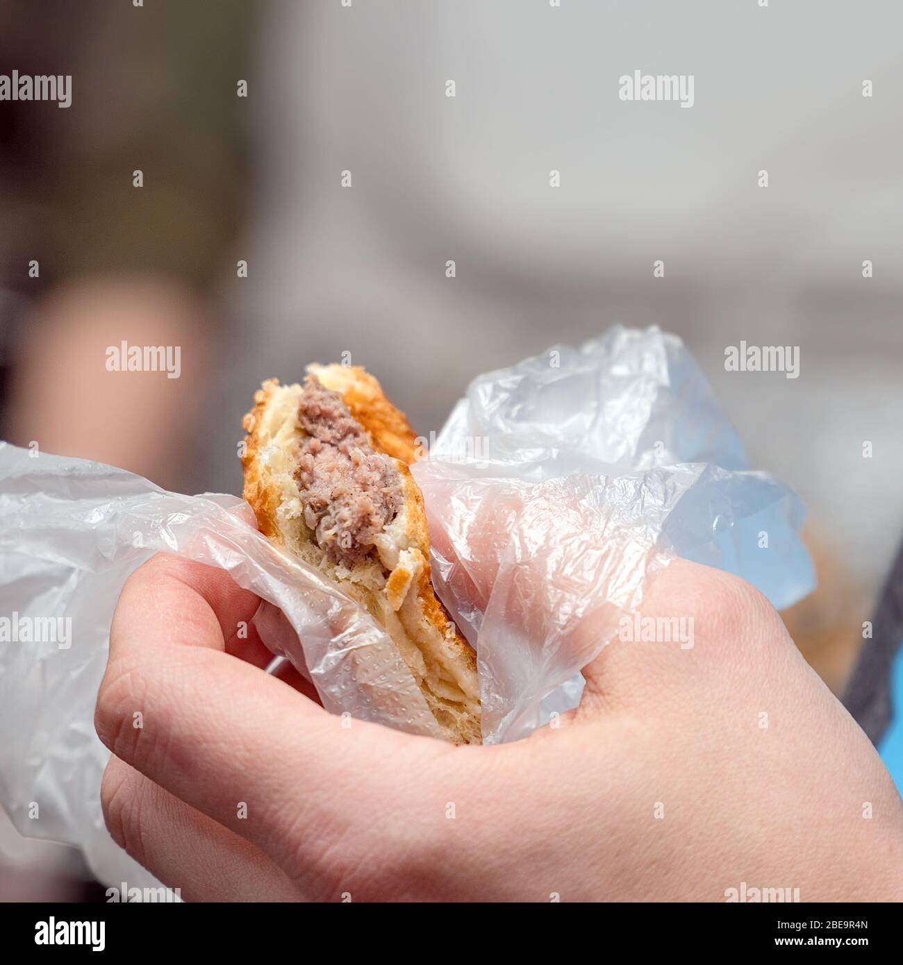 L'homme tient un hamburger de viande hachée. Restauration rapide dans la rue Banque D'Images