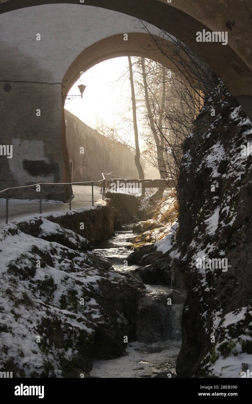 Passerelle et ruisseau d'eau le long des murs fortifiés entourant la ville de Brasov, Roumanie Banque D'Images