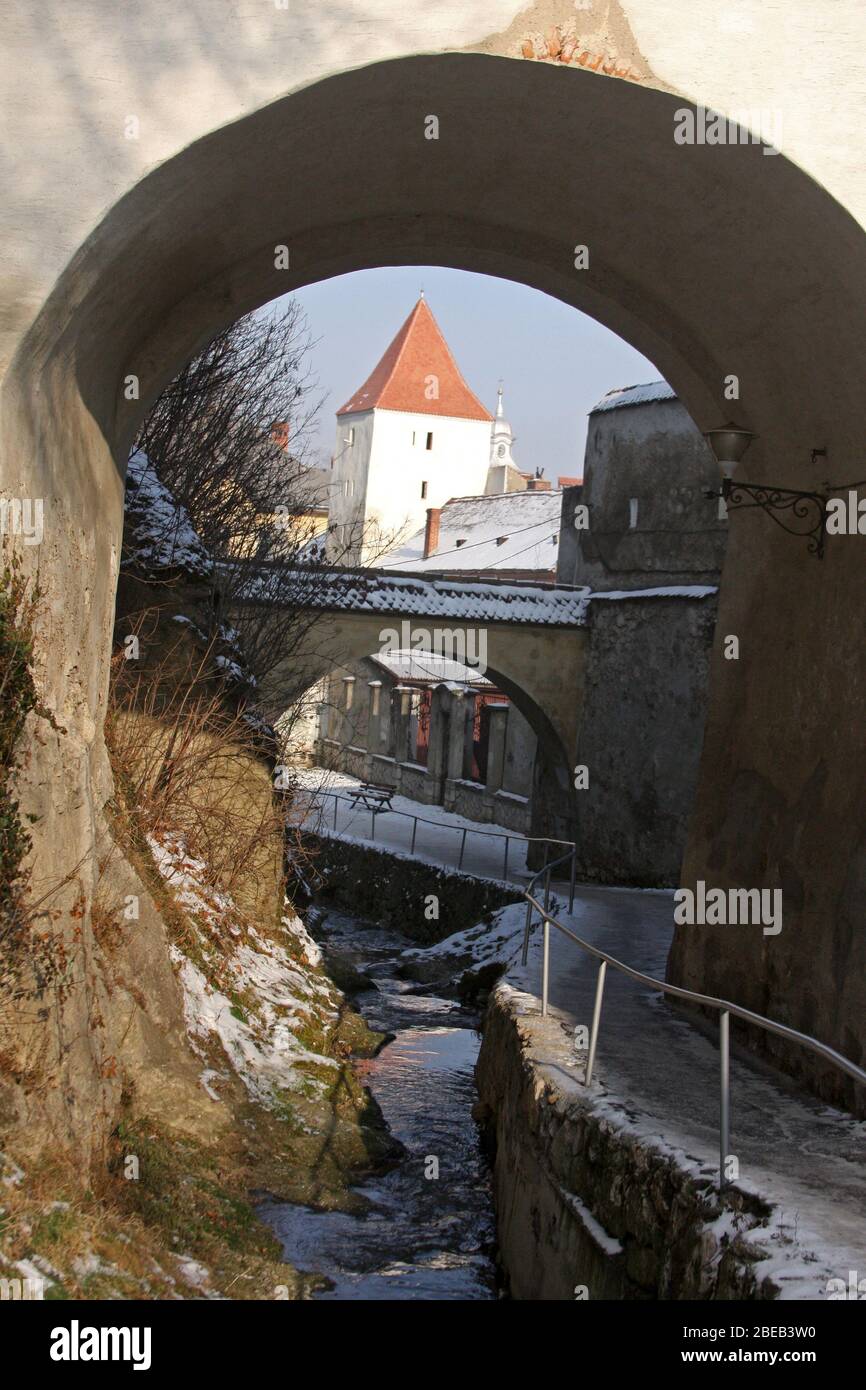 Passerelle et ruisseau d'eau le long des murs fortifiés entourant la ville de Brasov, Roumanie Banque D'Images