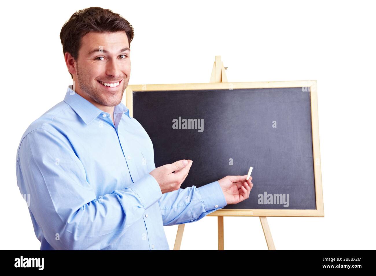 Un professeur en riant se tient à craie devant un tableau noir Banque D'Images
