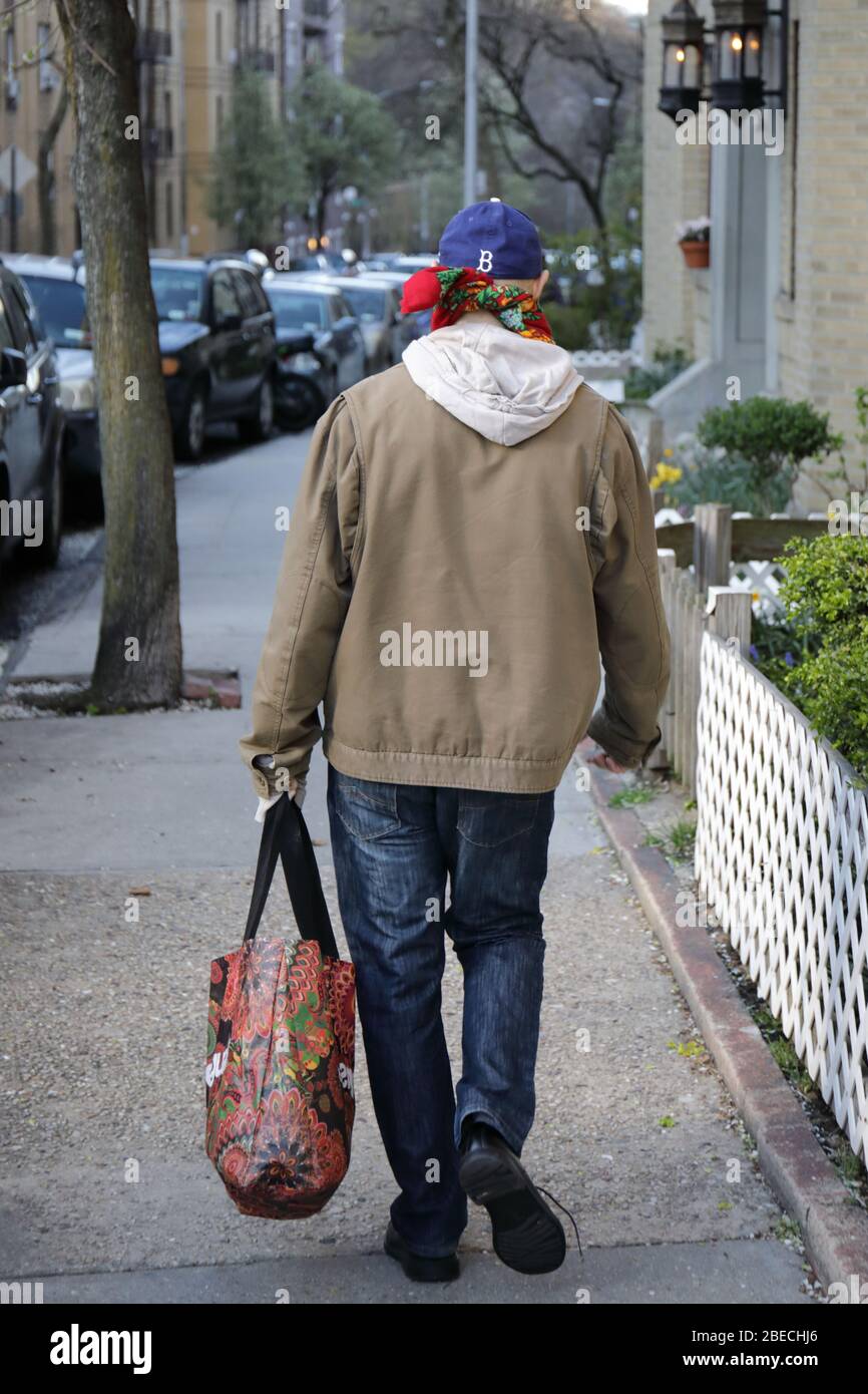 Un vieux mâle va à l'épicerie pour acheter des marchandises pendant l'éclosion de COVID-19 Banque D'Images