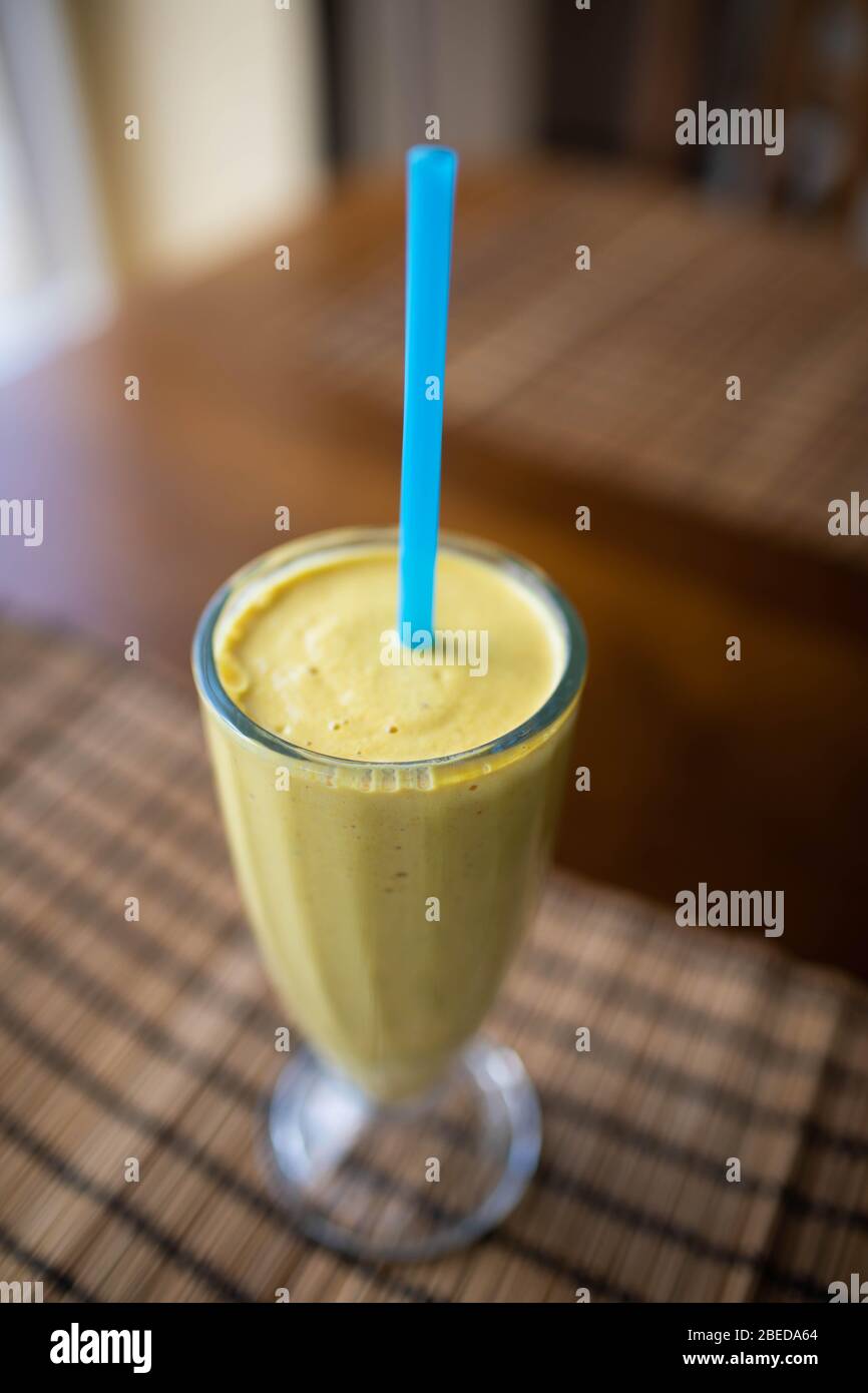 Smoothie aux fruits verts fraîchement mélangé dans un bocal en verre avec de la paille. Fond bleu turquoise, copy space Banque D'Images