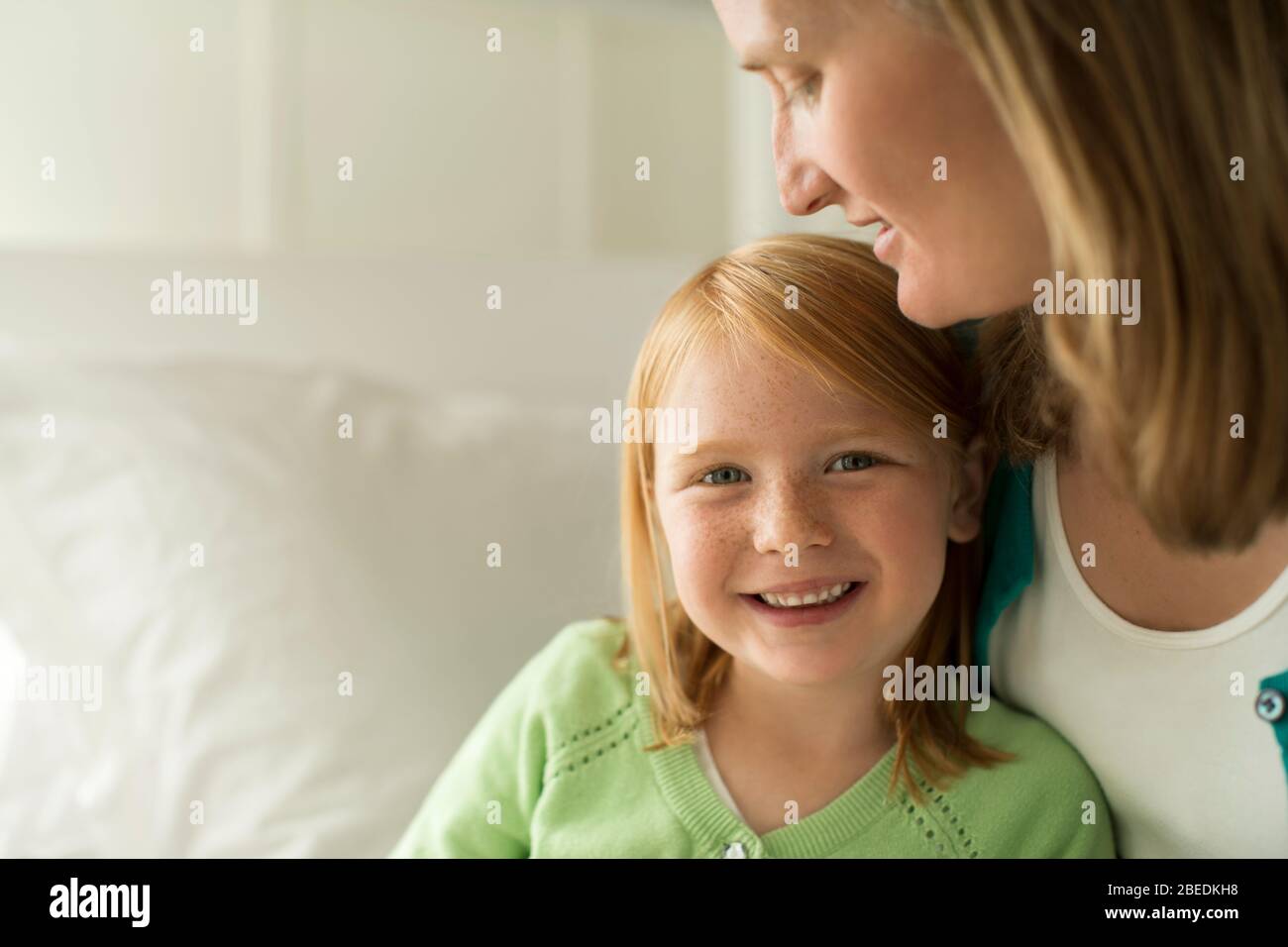 Portrait d'une jeune fille souriante assise avec sa mère Banque D'Images