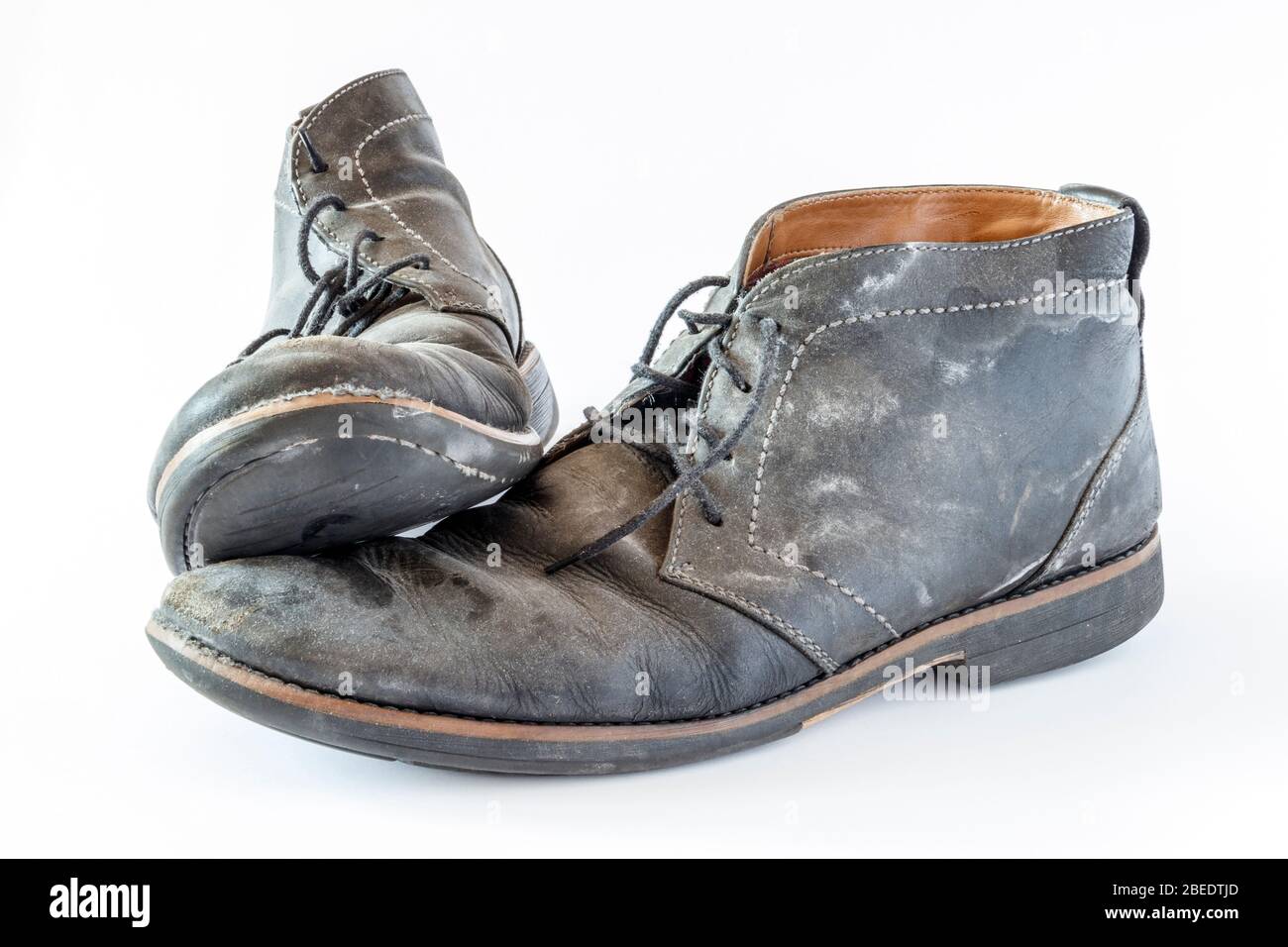 Paire de chaussures en cuir noir sale usées isolées sur fond blanc Banque D'Images