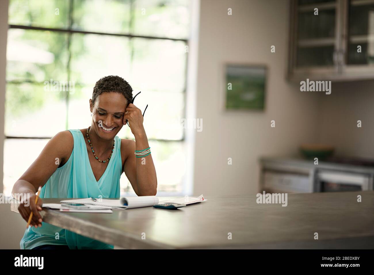 Femme adulte moyenne travaillant sur les finances de la famille à la maison Banque D'Images