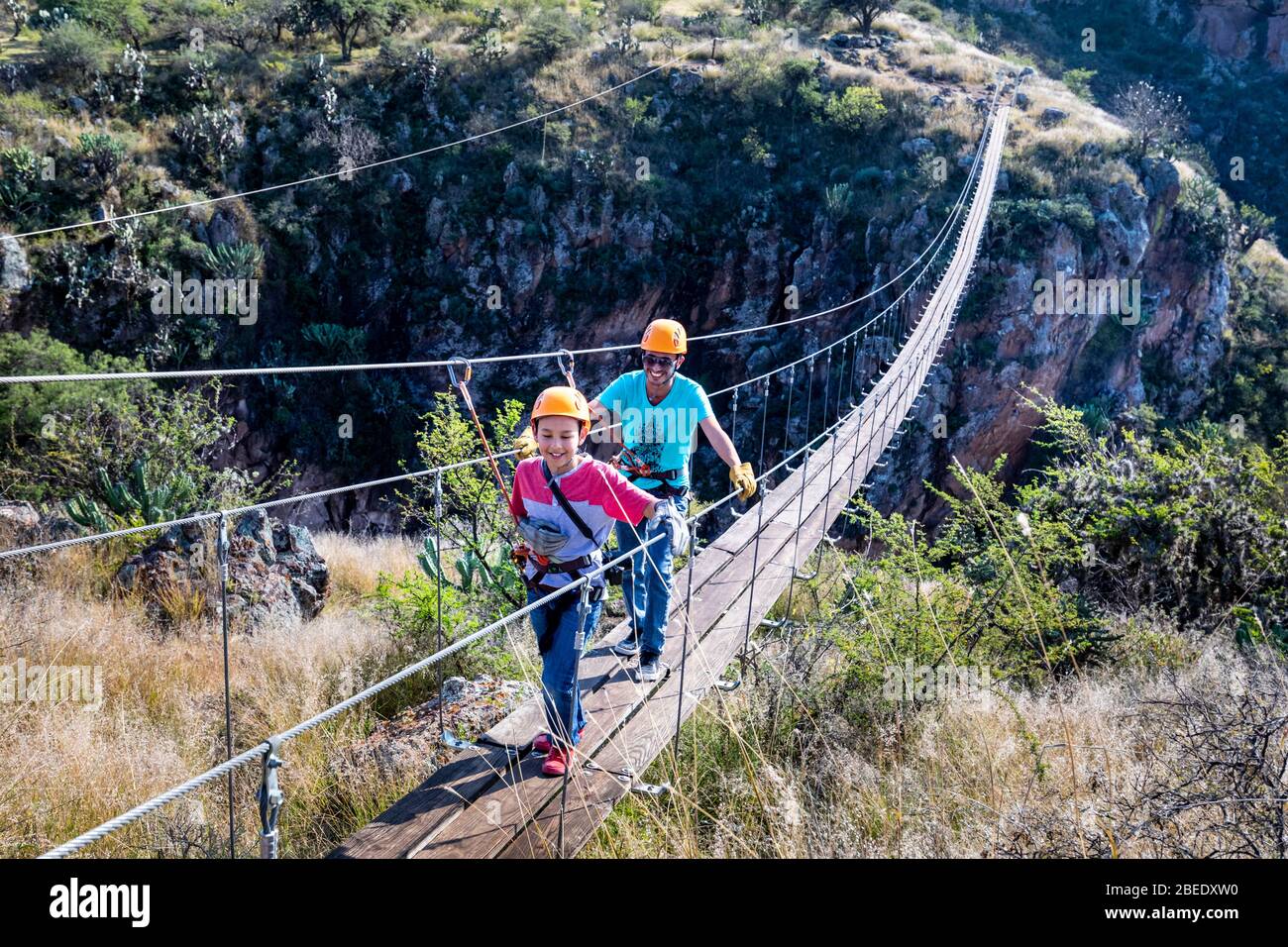 Père et fils sur un pont de randonnée qui s'étend sur le Cañon Aguila Cola Roja (Red Tait Eagle Canyon) près de San Miguel de Allende, Mexique. Banque D'Images