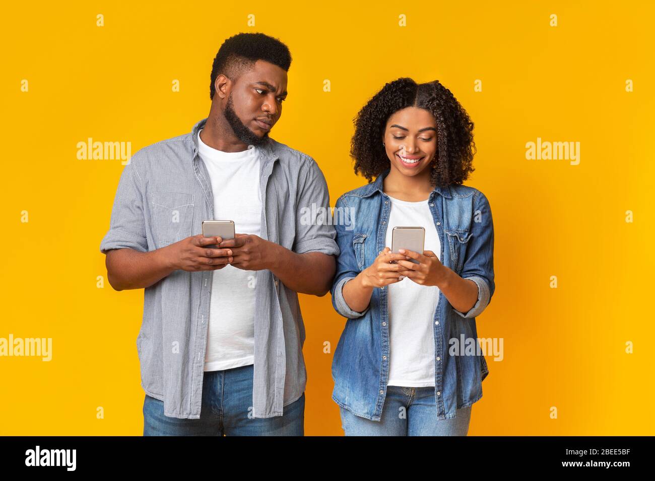 Un gars noir jaloux qui espionnage le téléphone de la petite amie, essaie de lire des messages Banque D'Images